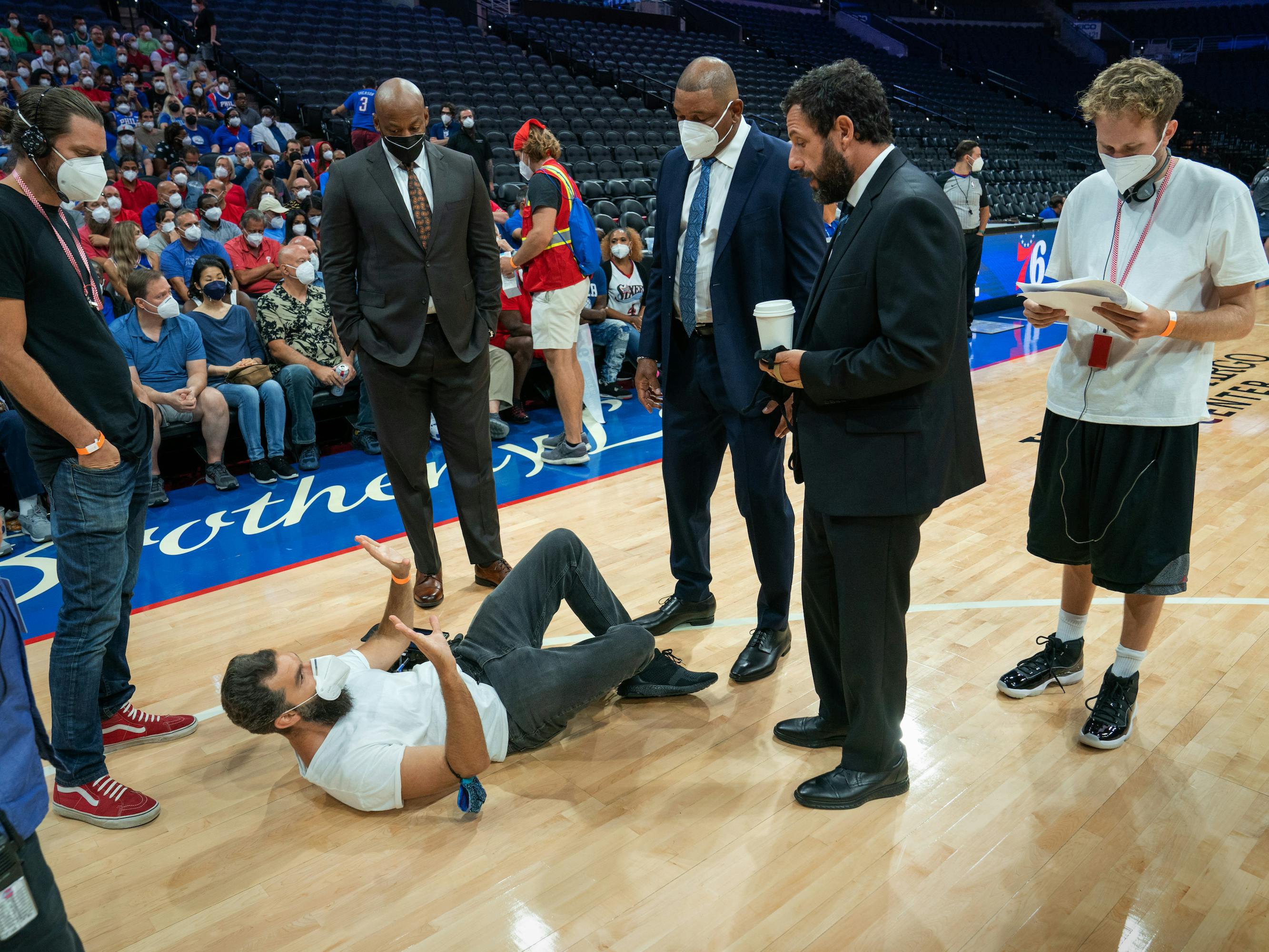Zak Mulligan, Jeremiah Zagar, Dell Demps, Doc Rivers, Stanley Sugarman (Adam Sandler), and Joseph Vecsey stand around behind the scenes.