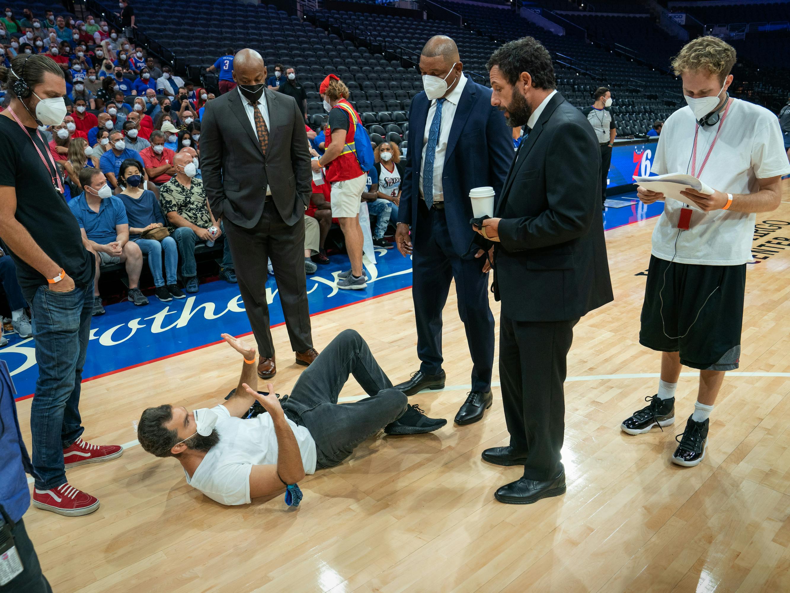 Zak Mulligan, Jeremiah Zagar, Dell Demps, Doc Rivers, Stanley Sugarman (Adam Sandler), and Joseph Vecsey stand around behind the scenes. 