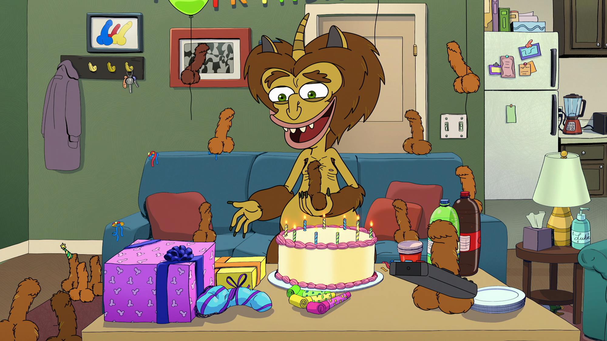 A hormone monster looks delightedly at a cake, presents, and dildos scattered about his messy room.