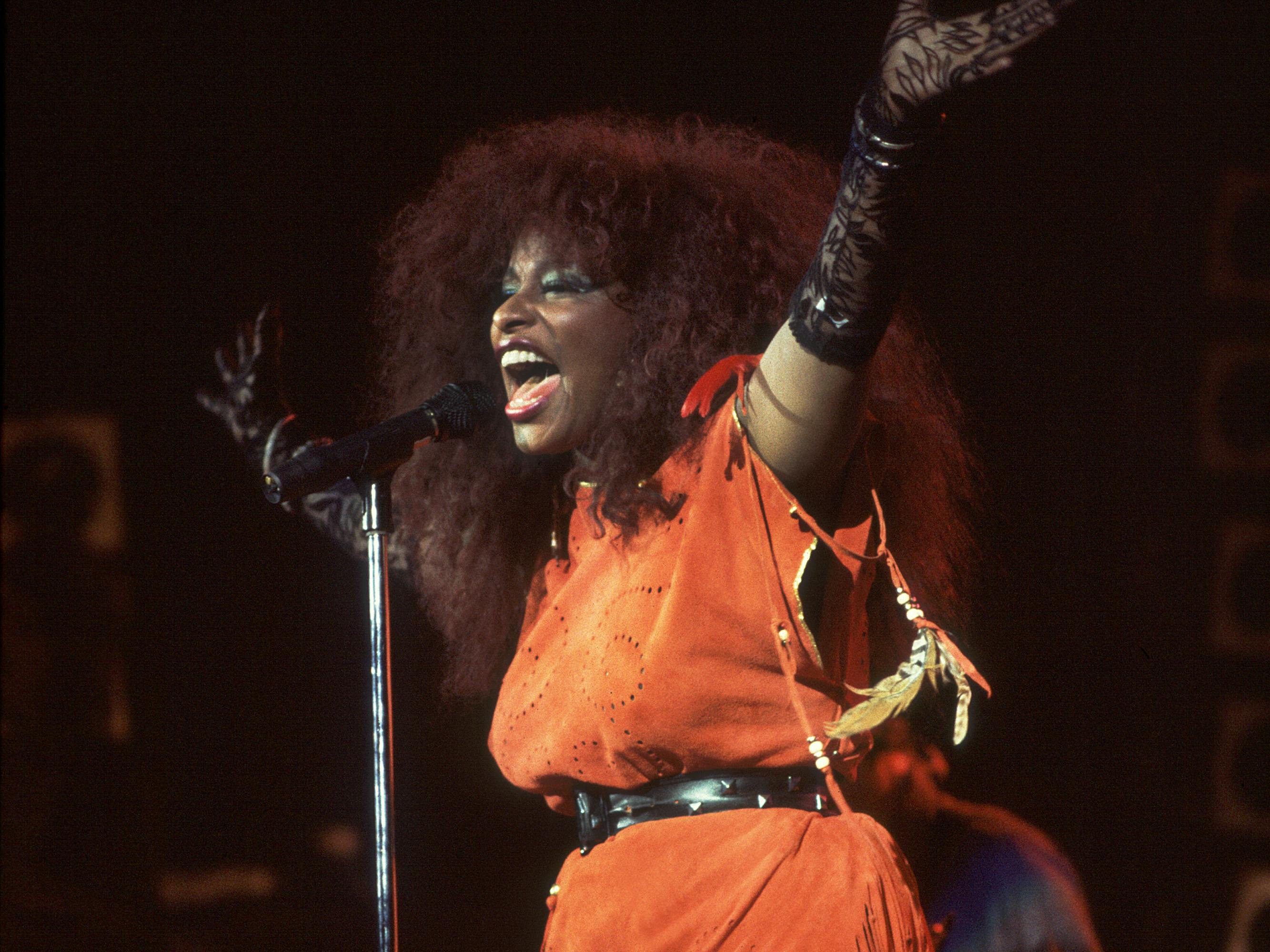 Chaka Khan at the Bismark Theater in Chicago, Illinois, November 17, 1984. She wears an orange fringe dress, black belt, black lace gloves, and bright green eyeshadow.