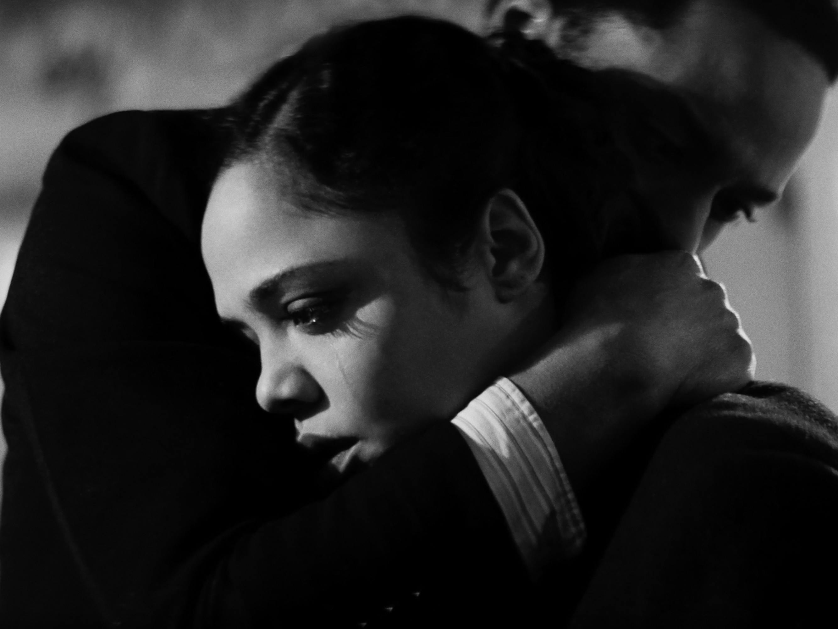 André Holland and Tessa Thompson embrace in this black and white shot. Thompson looks desolate.