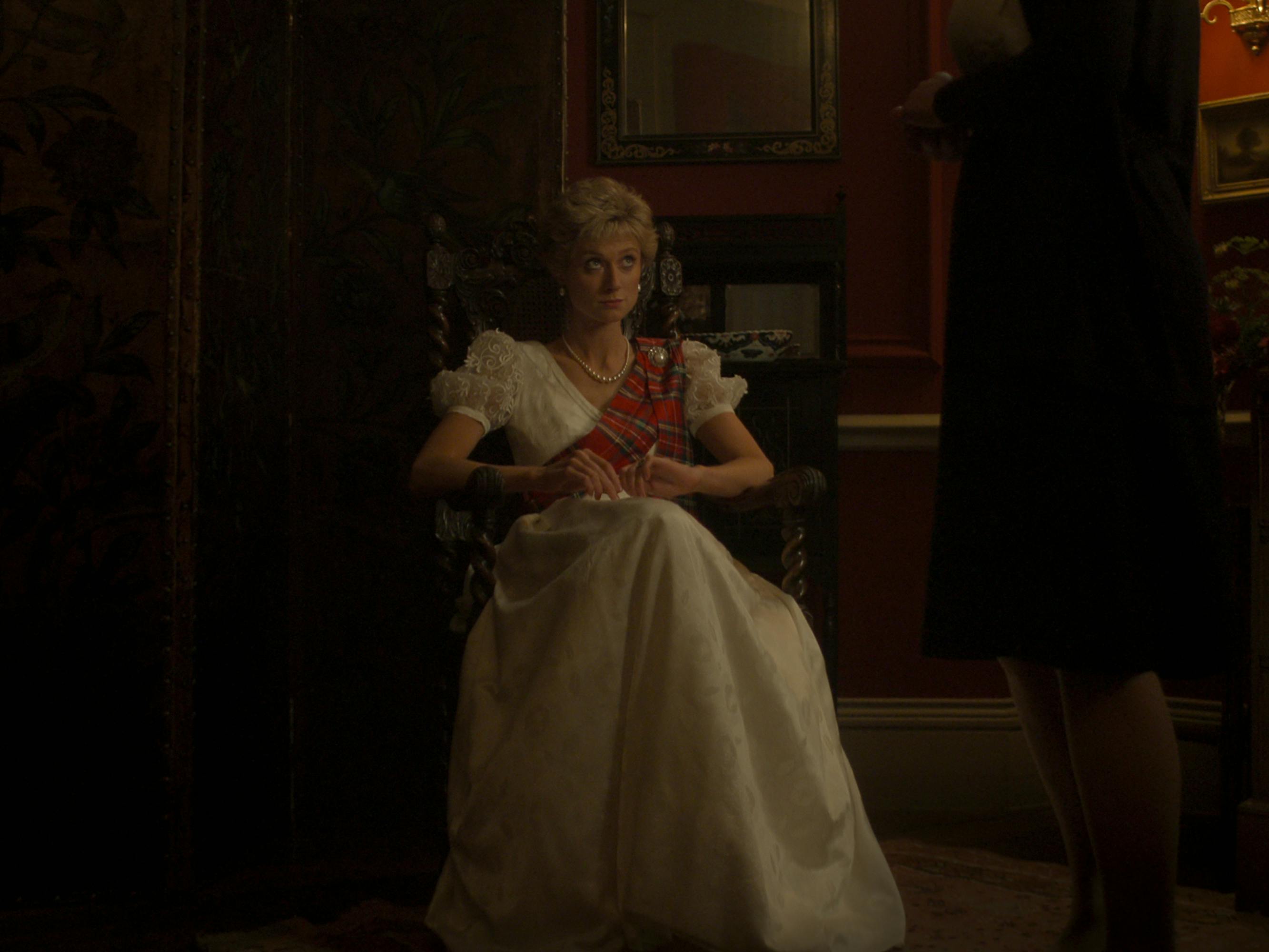 Princess Diana (Elizabeth Debicki) looks beleaguered sitting in a chair wearing a puffy white dress.