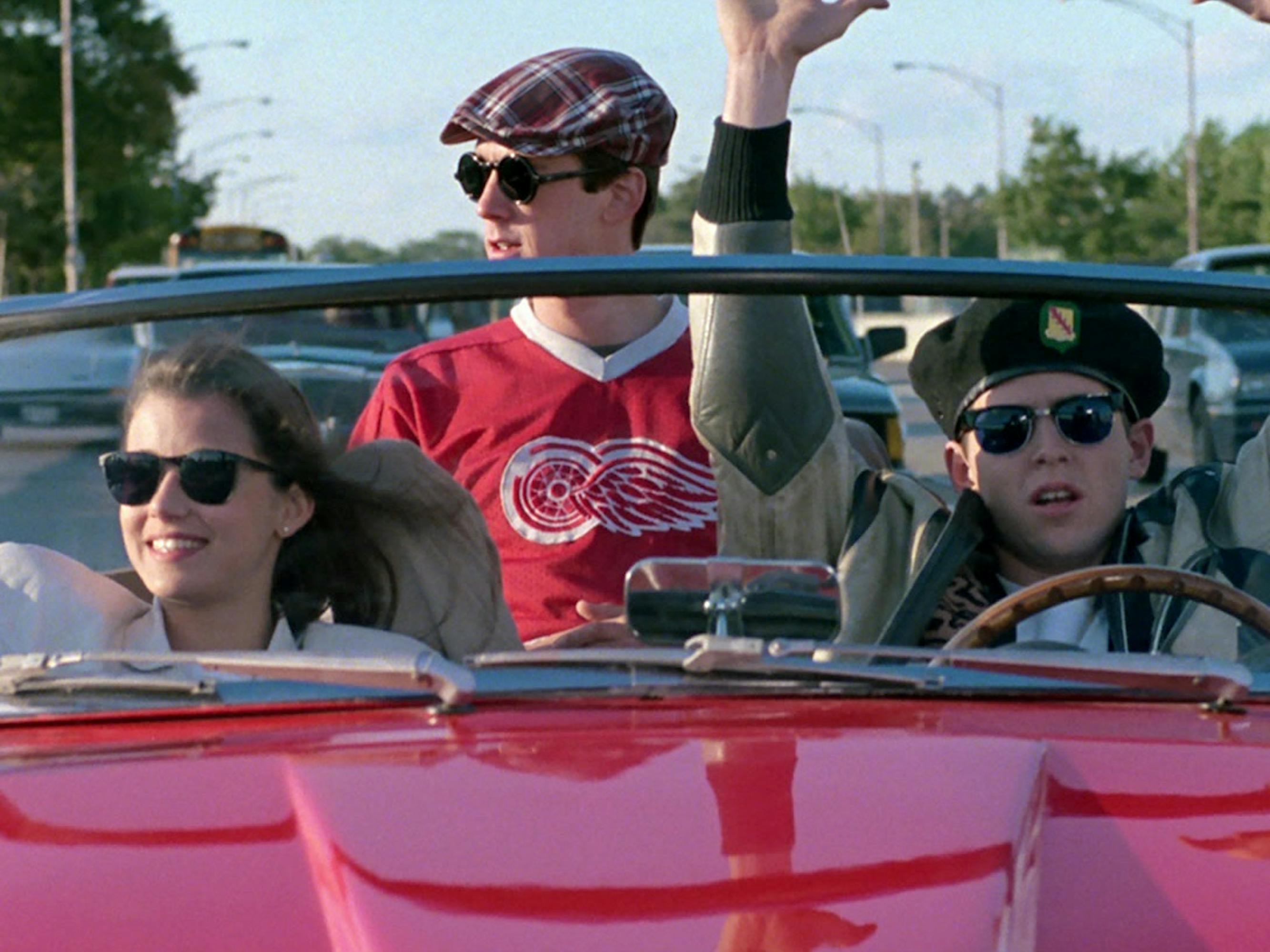 Sloane Peterson (Mia Sara), Cameron Frye (Alan Ruck), and Ferris Bueller (Matthew Broderick) in a red convertible.