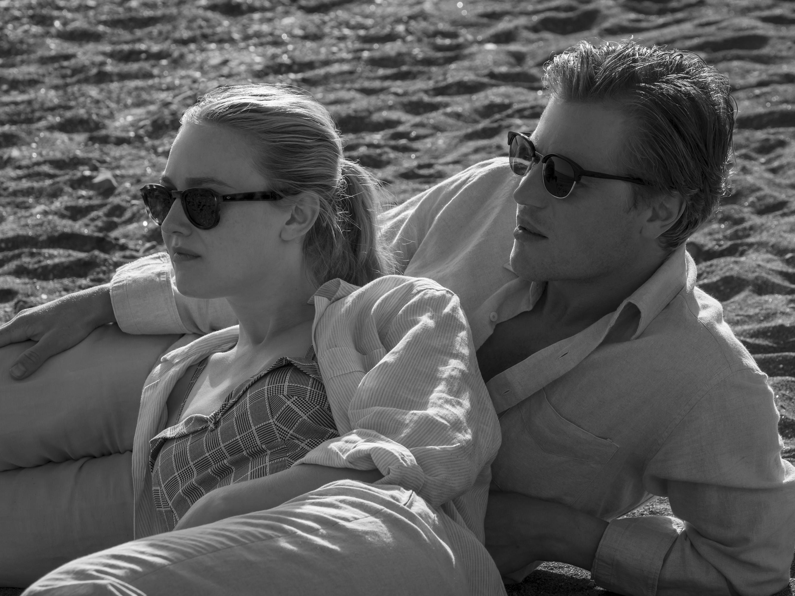 Marge Sherwood (Dakota Fanning) and Dickie Greenleaf (Johnny Flynn) lie on a beach looking glamorous.