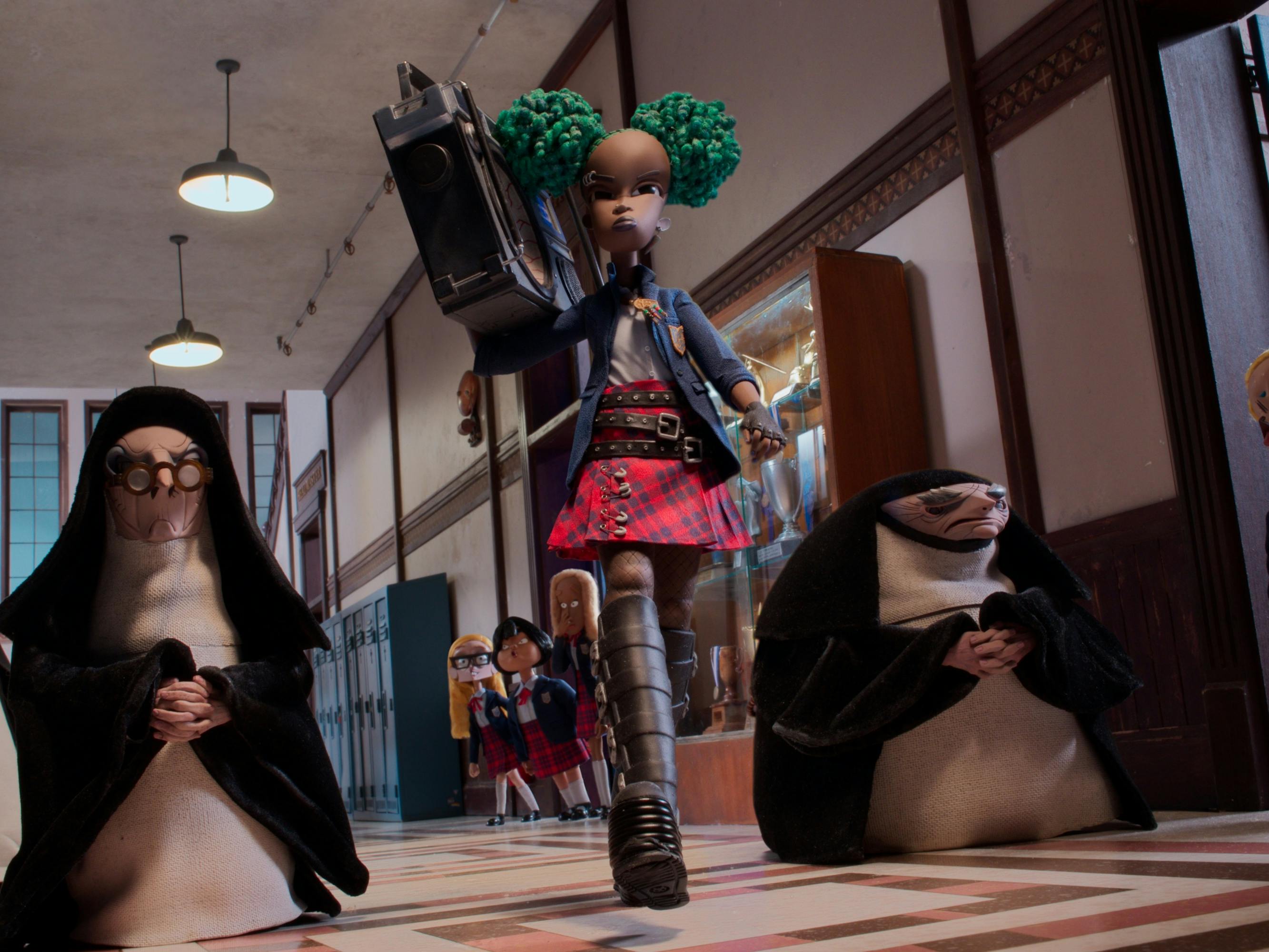 Kat (Lyric Ross) walks through a hallway of nuns and prim school girls, wearing sky high boots, a red skirt, carrying a boombox, with green hair.