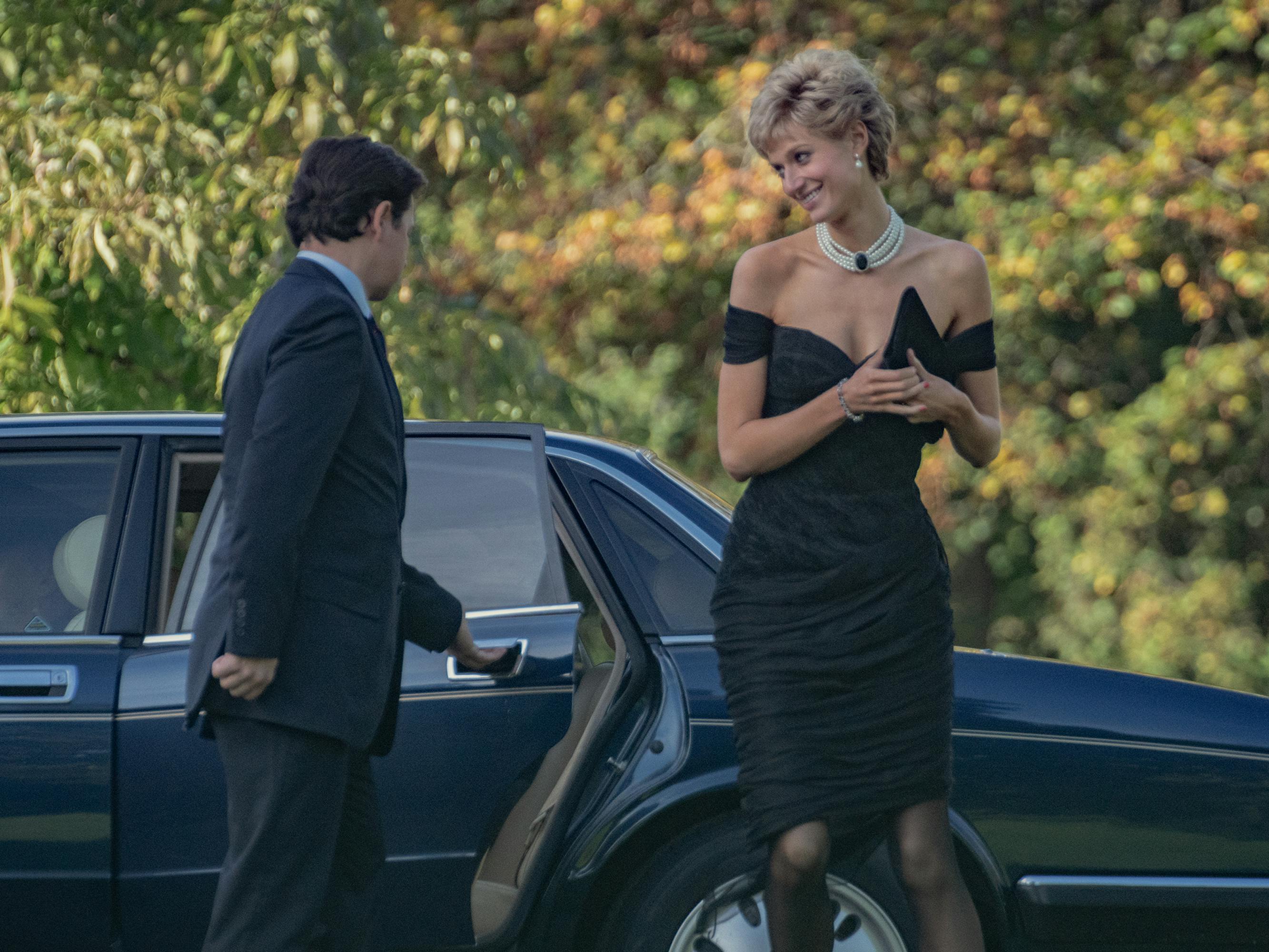 Princess Diana (Elizabeth Debicki) disembarks from a black car, wearing the iconic revenge dress.