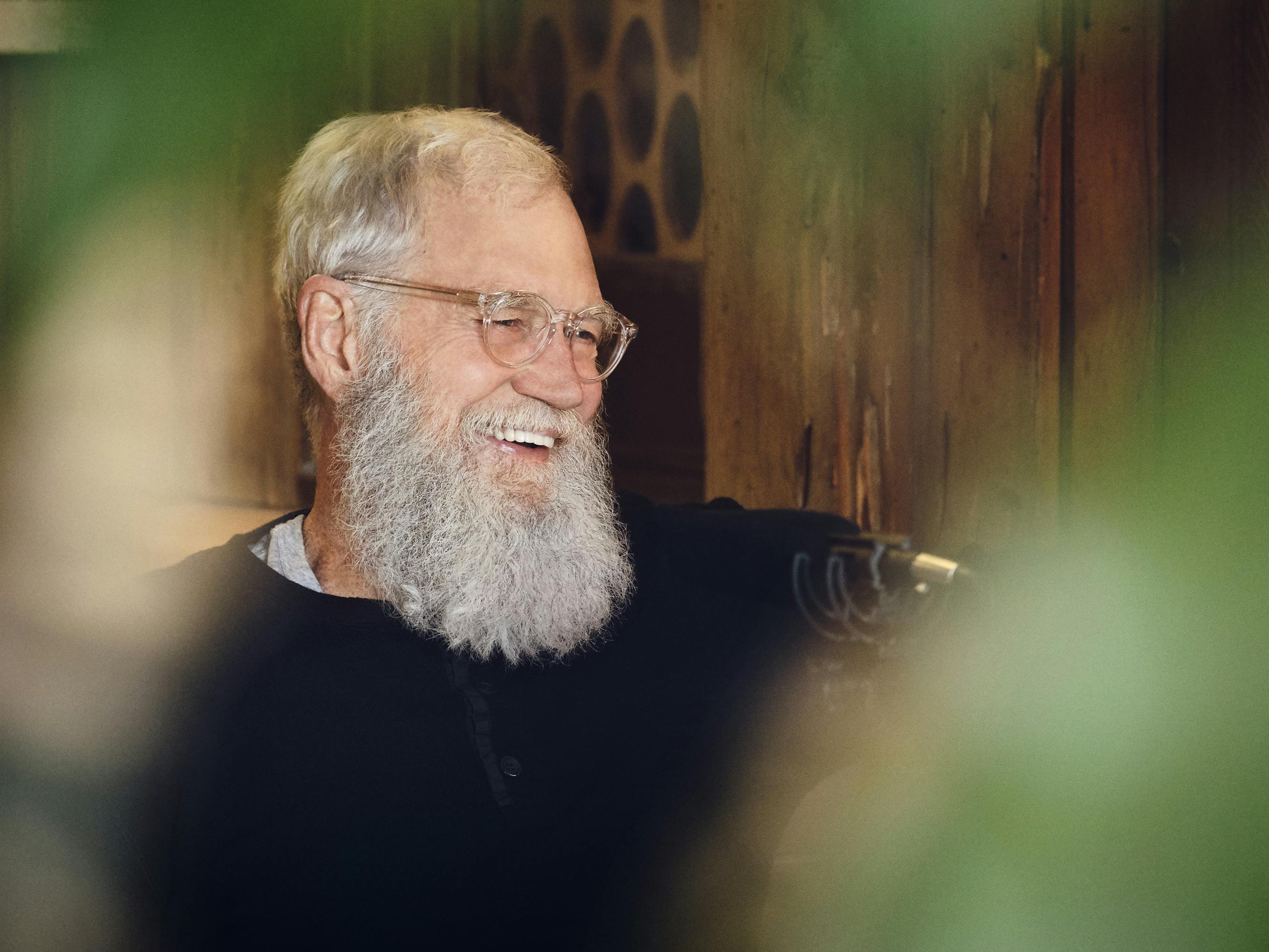 David Letterman wears a dark sweater and smiles.