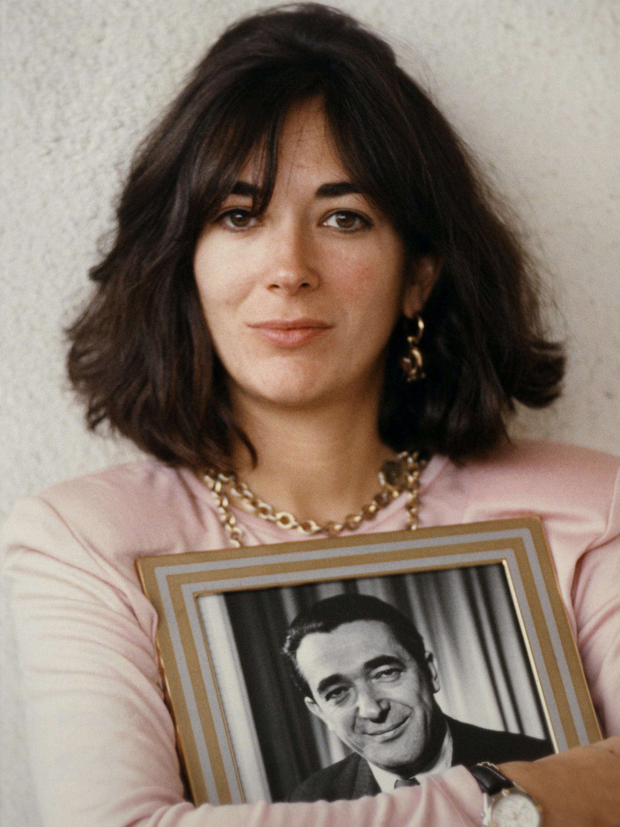 Ghislaine Maxwell wears gold jewelry and a pink top. 