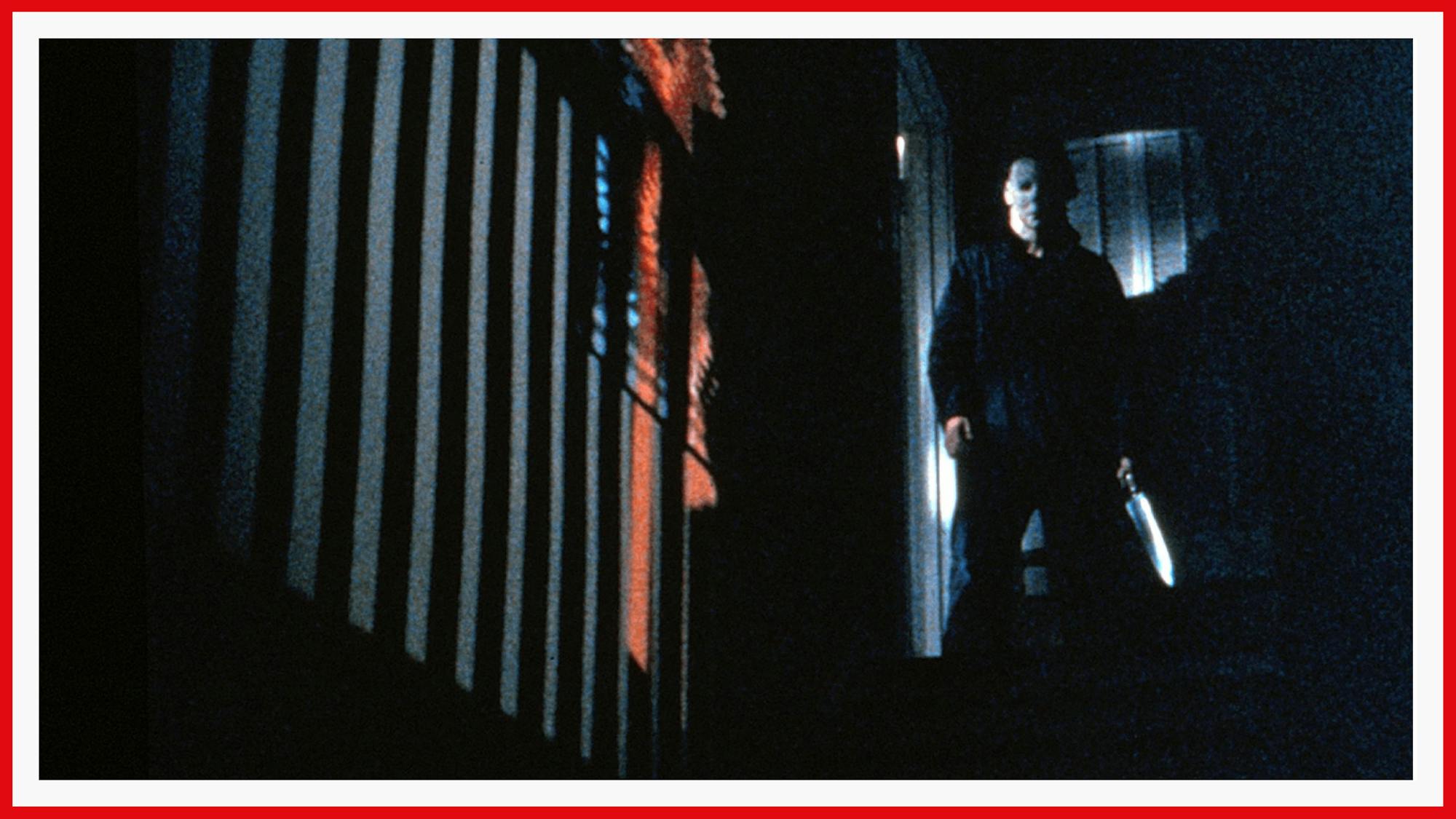 Castle as Michael Myers stands threatening in the dim, the blade of his knife shining.