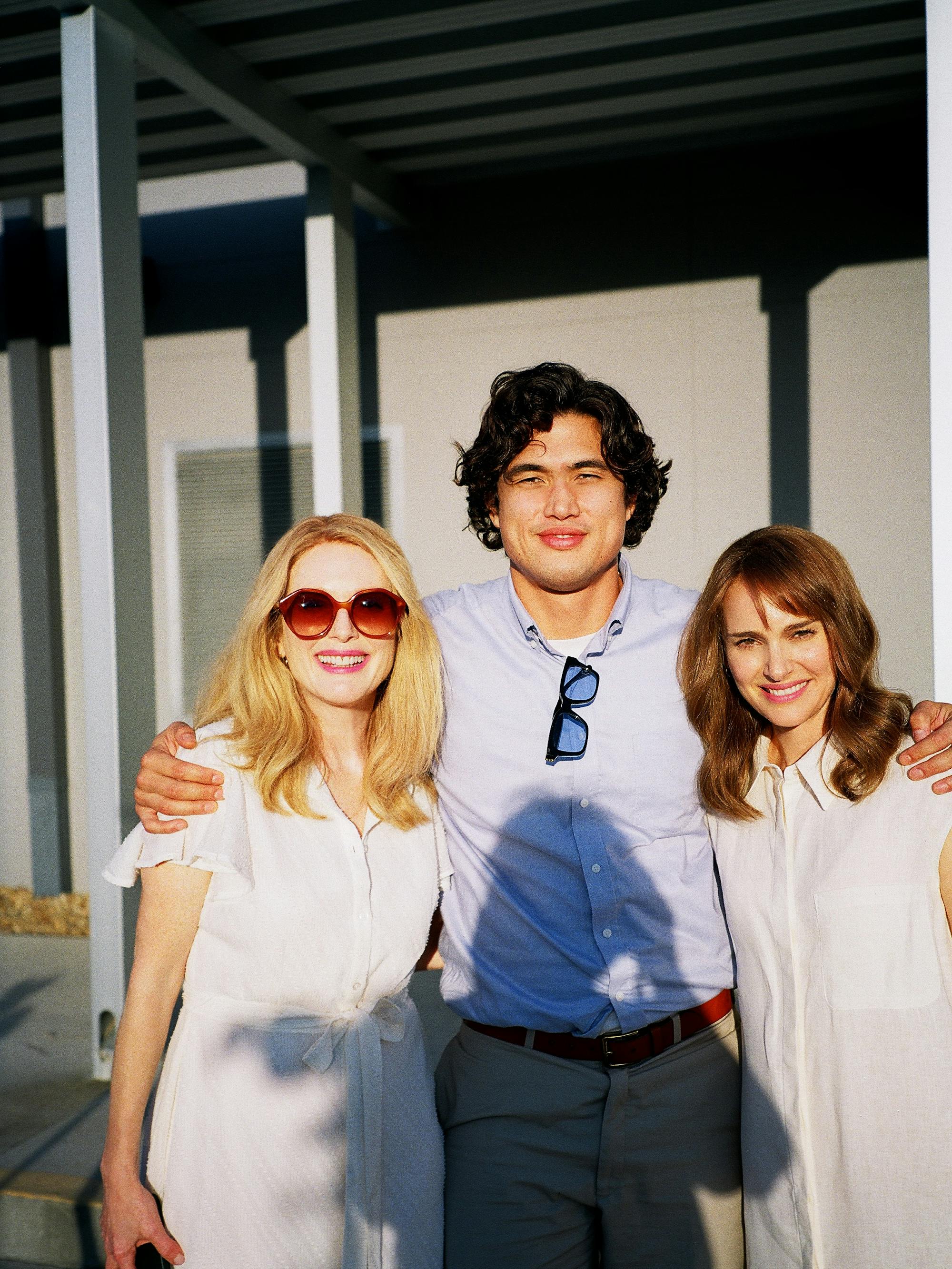 Julianne Moore, Charles Melton, and Natalie Portman stand together in a sunny shot.