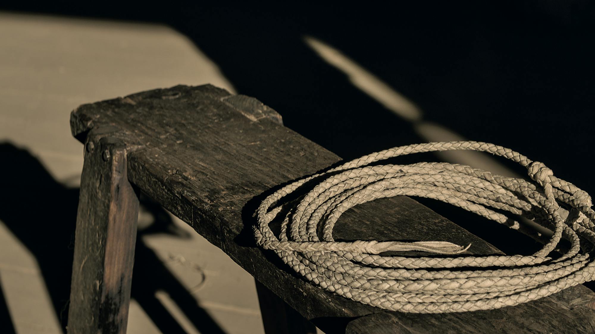 A lasso on a wooden bench.