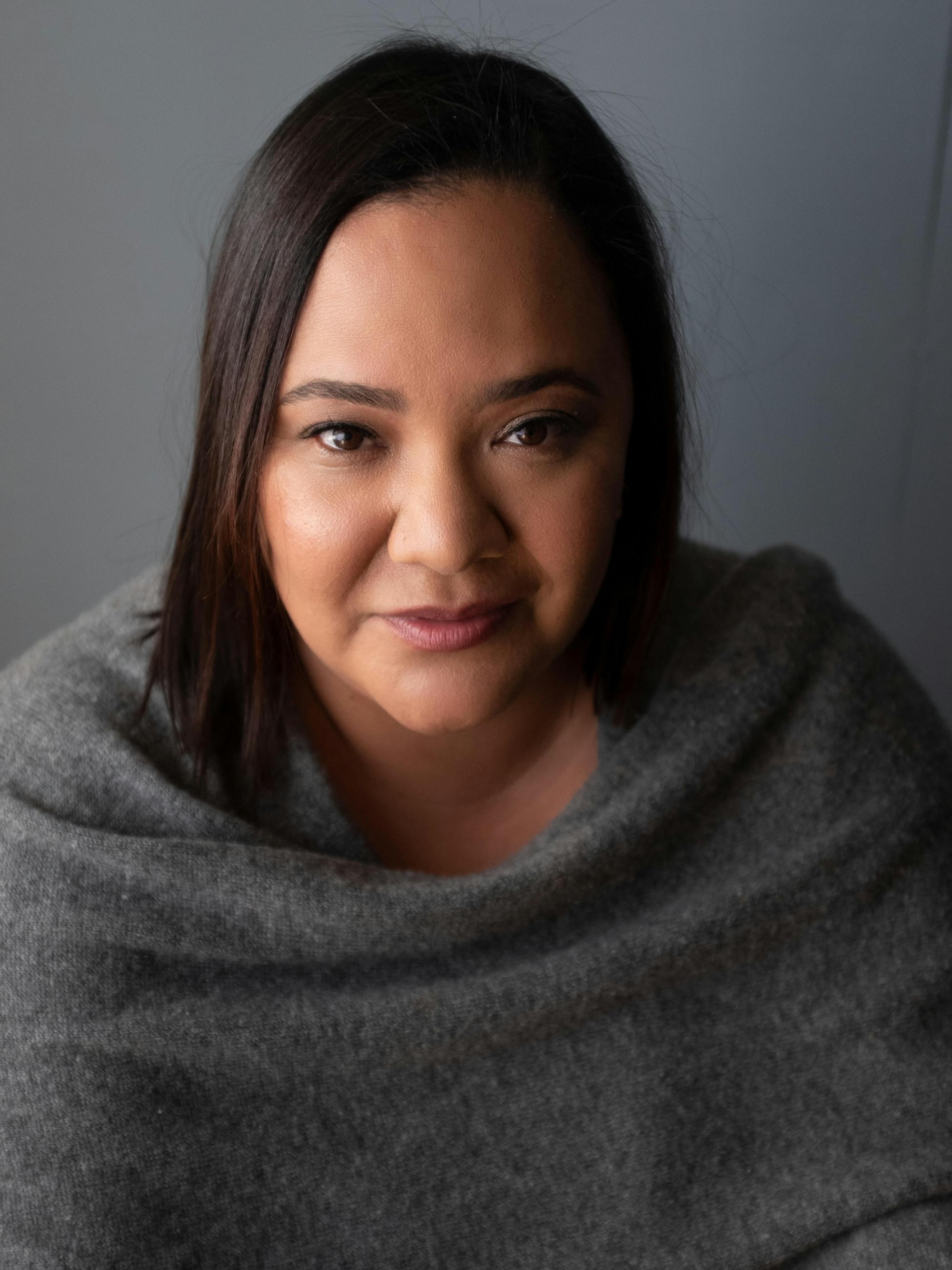 dream hampton wears a grey poncho against a grey background.