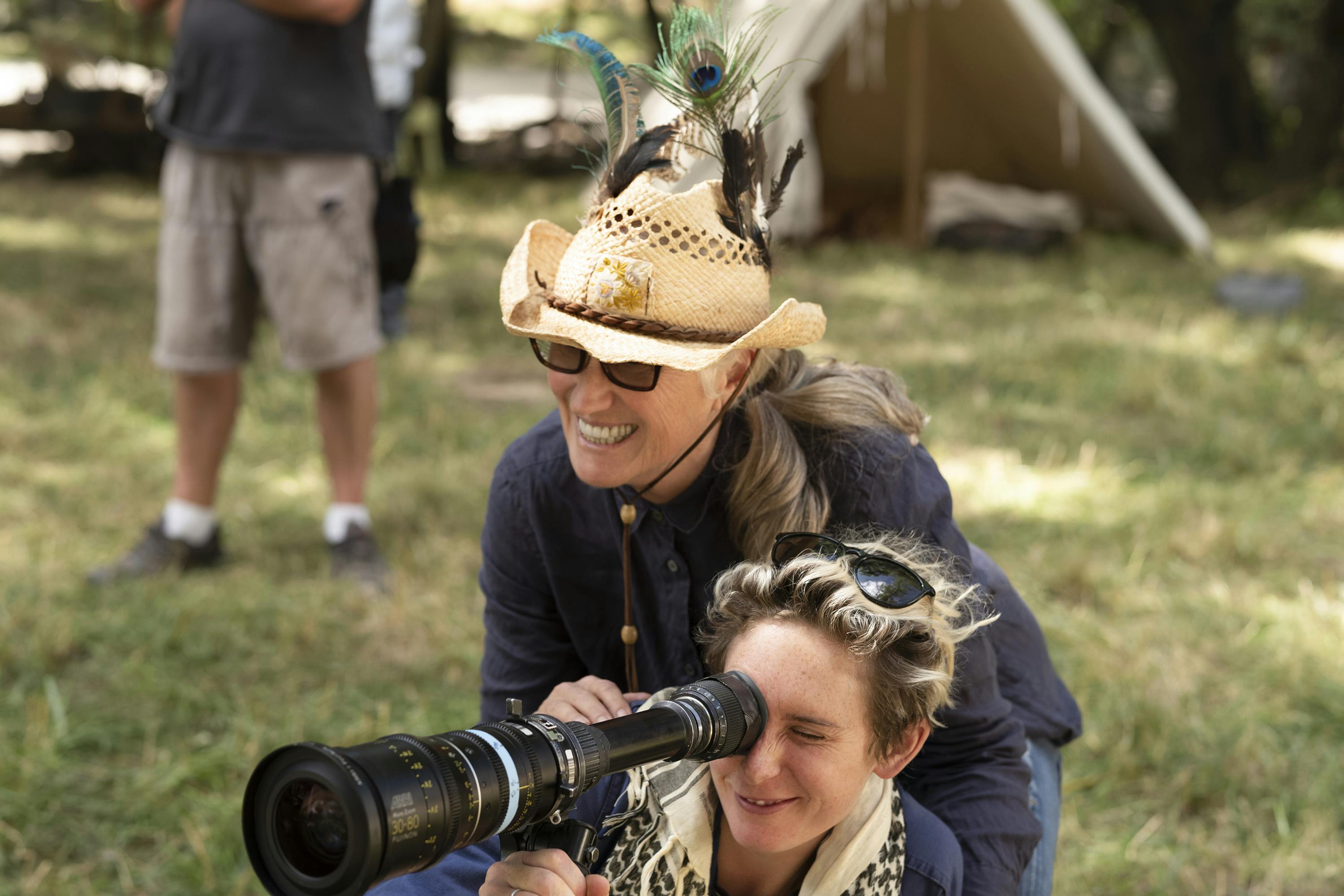 Cinematographer Ari Wegner and Director Jane Campion on the set of The Power of the Dog looking through a scope together to frame up a scene. 