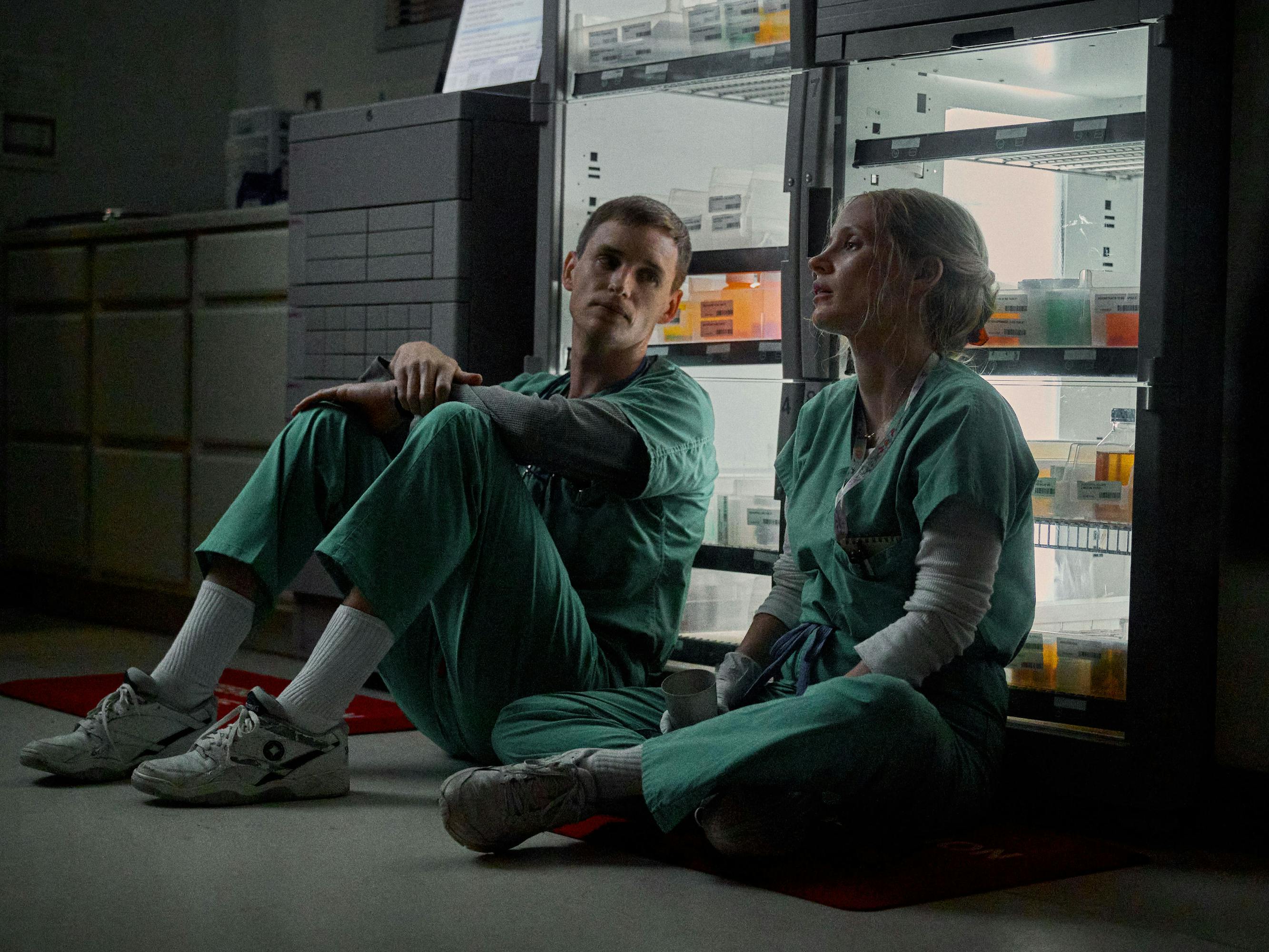 Charlie Cullen (Eddie Redmayne) and Amy Loughren (Jessica Chastain) sit on the ground of the hospital.  