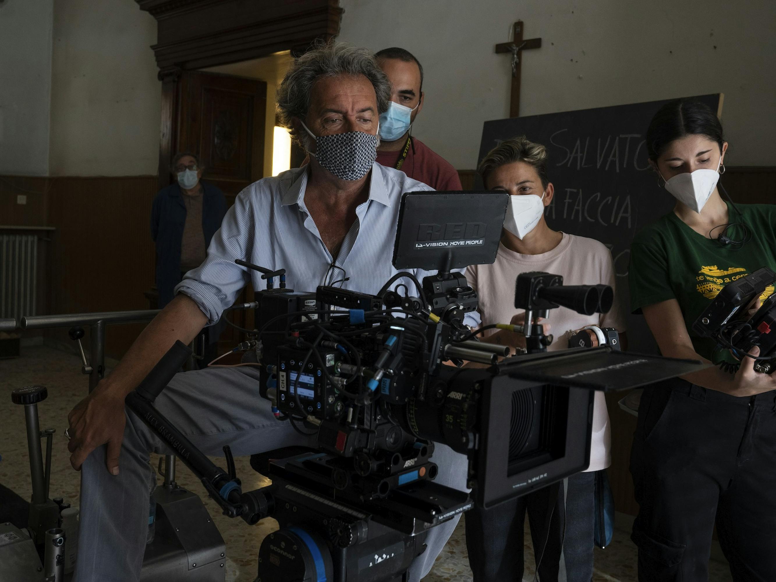 Paolo Sorrentino, Daria D’Antonio, and The Hand of God crew stand around camera gear, masked.