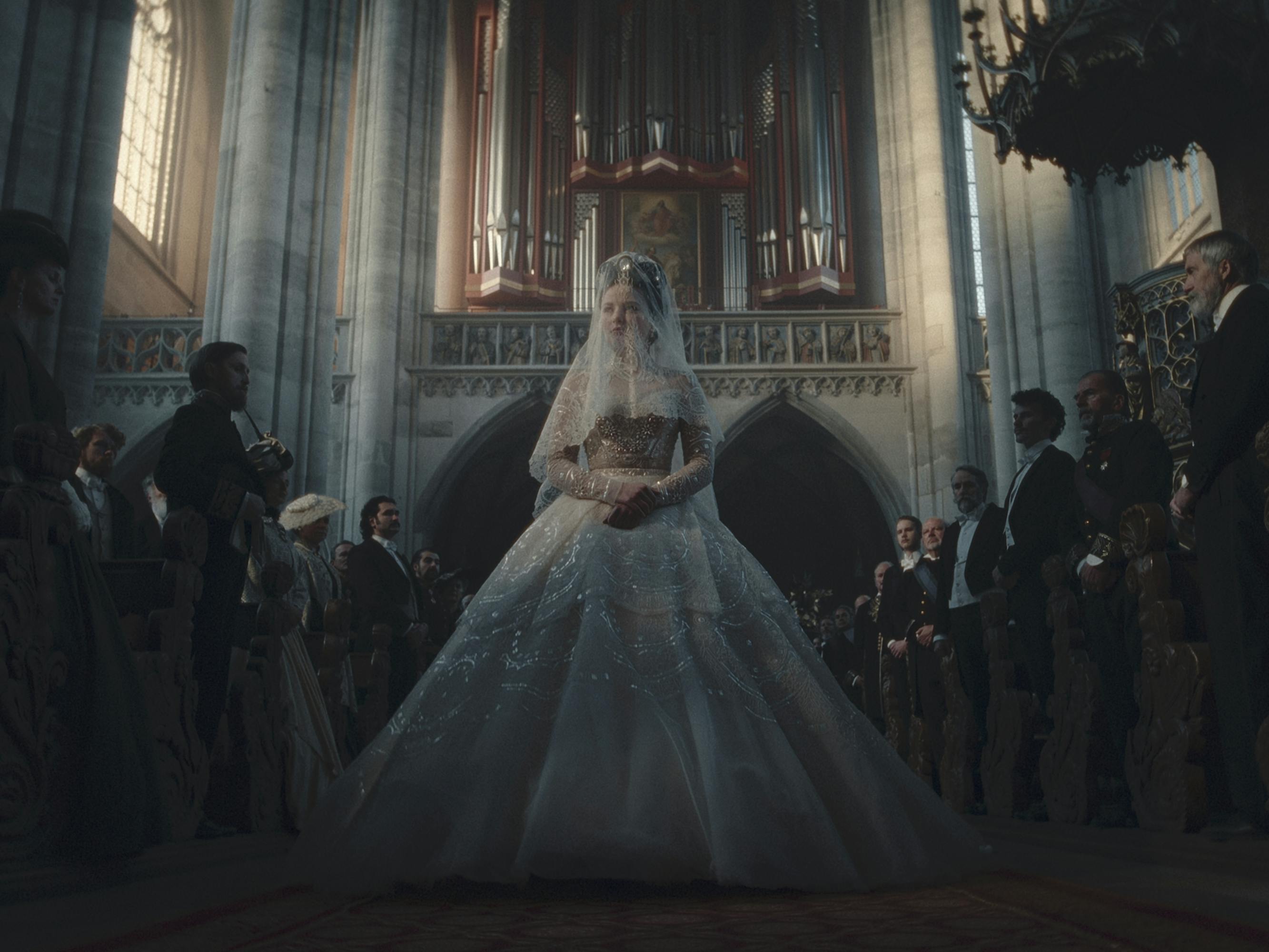 Elisabeth (Devrim Lingnau) wears an elaborate wedding dress and walks through a church.