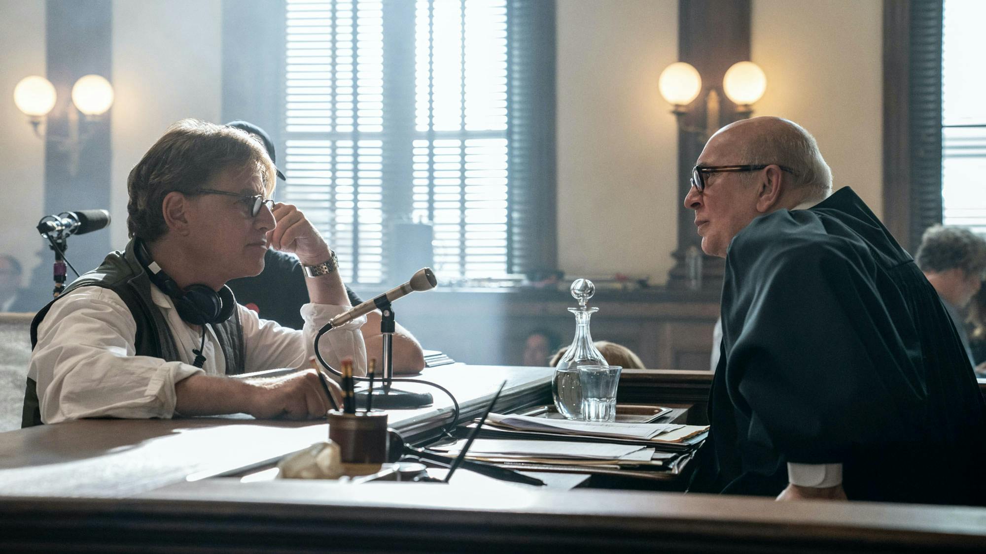 On the courtroom set, Sorkin has approached the bench to speak with Frank Langella, in costume as Judge Julius Hoffman. 