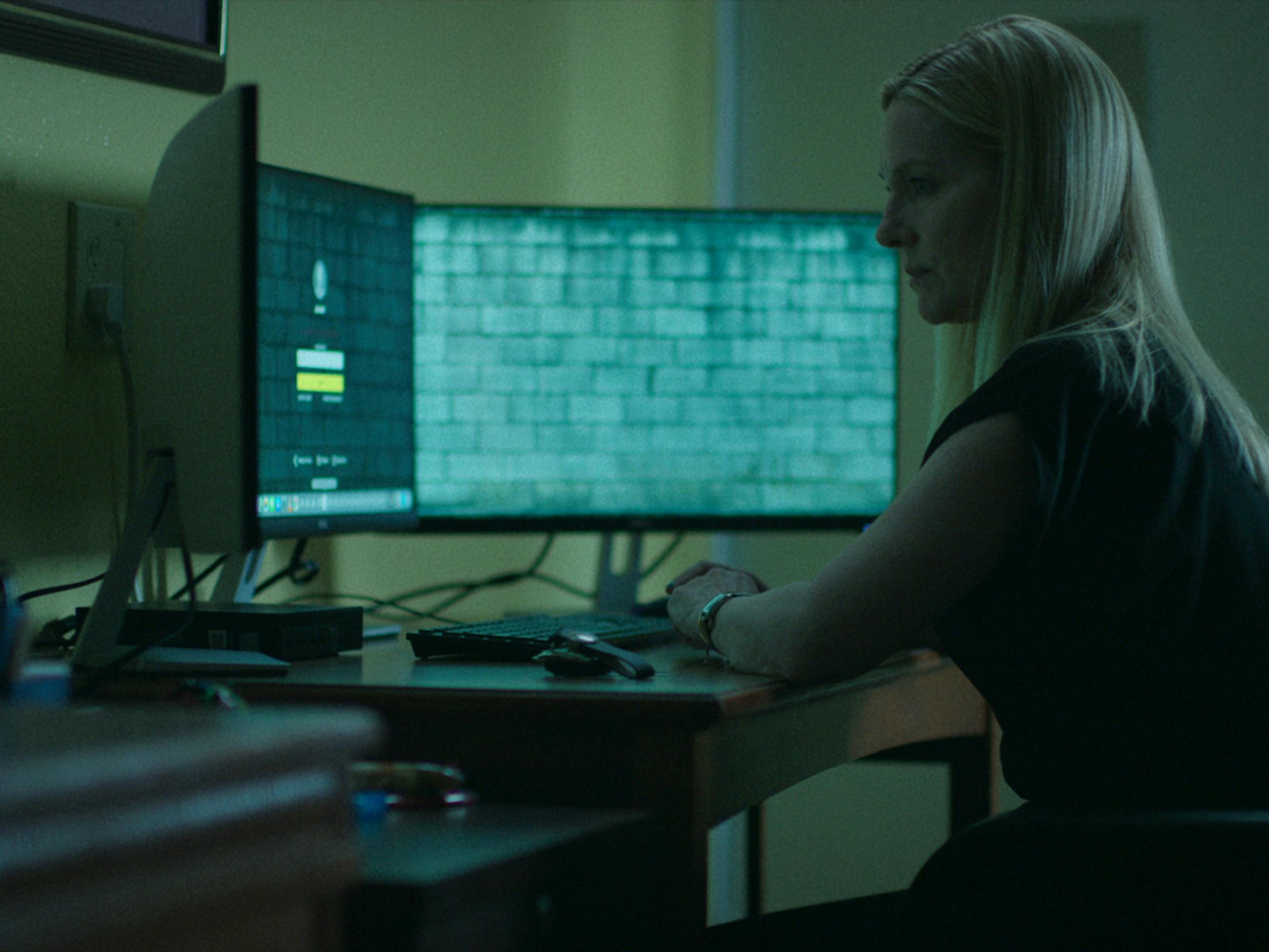Wendy Byrde (Laura Linney) sits behind a double monitor getting up to something nefarious.