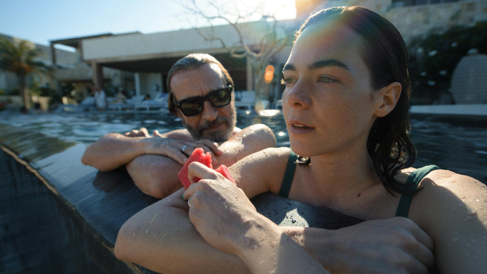 Daniel Giménez Cacho and Ximema Lamadrid sit in the pool.