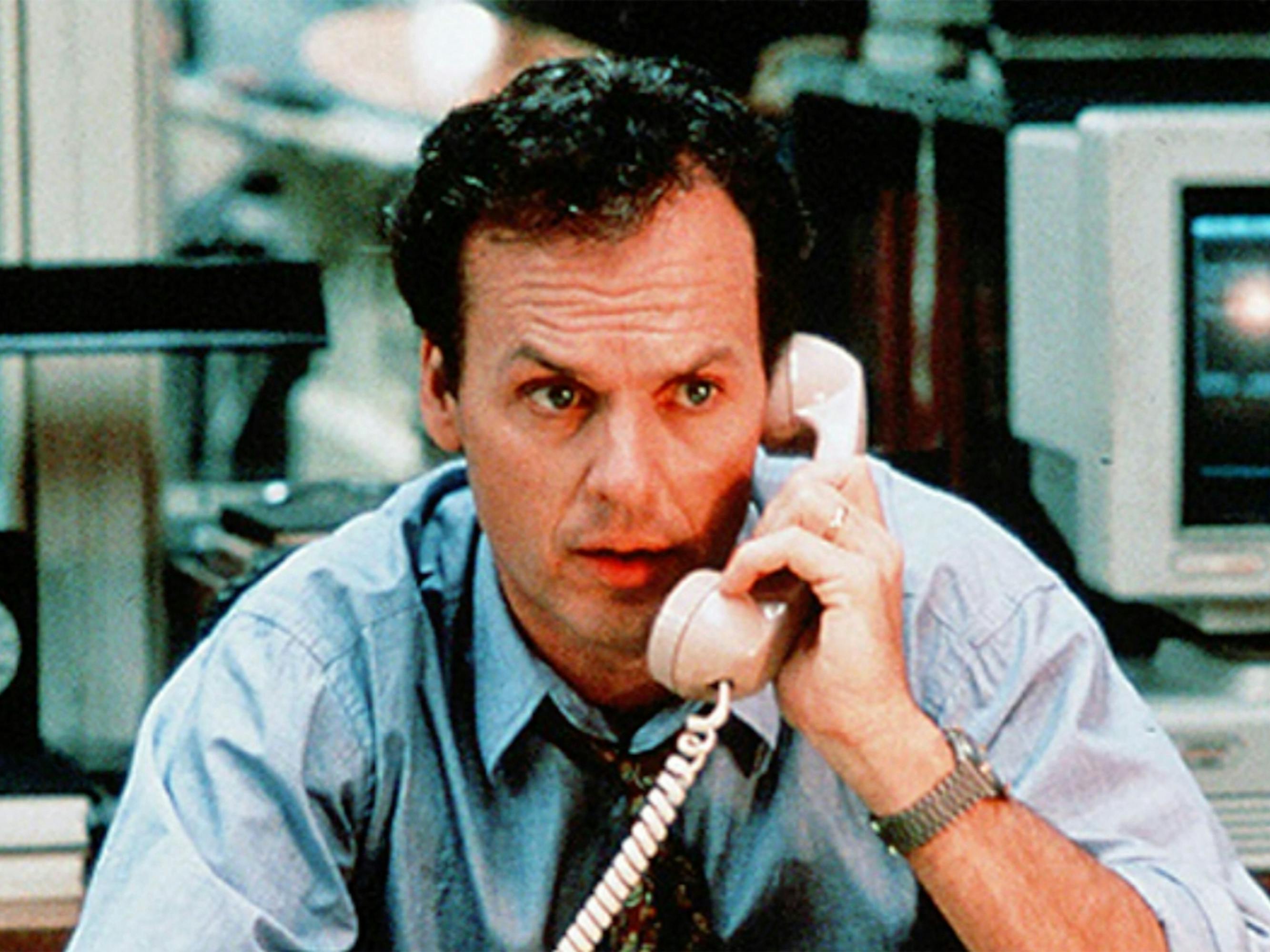 Henry Hackett (Michael Keaton) wears a blue shirt and talks on a phone with an alarmed look.