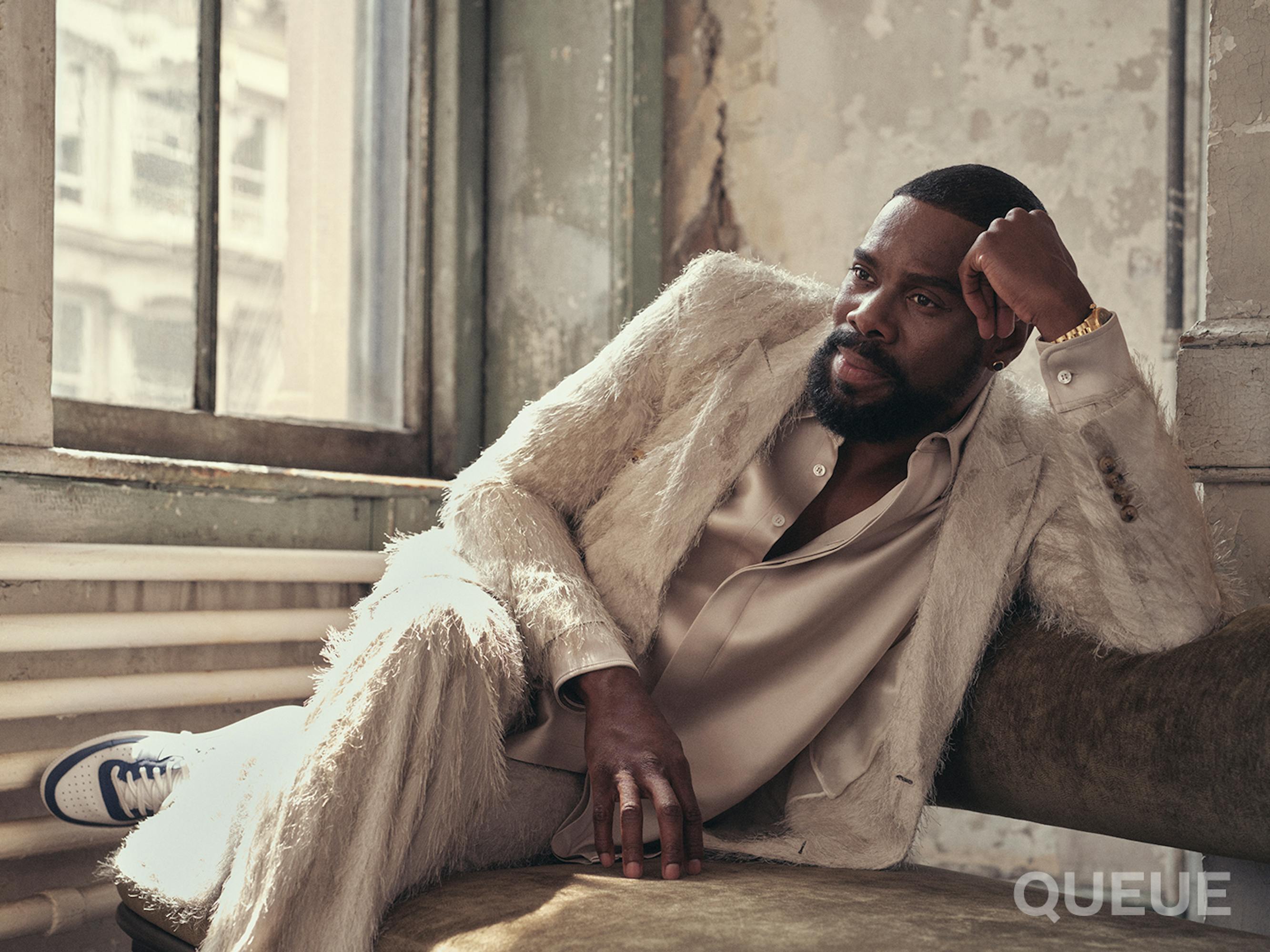 Colman Domingo wears a cream-colored ensemble complete with silky top and furry cardigan.
