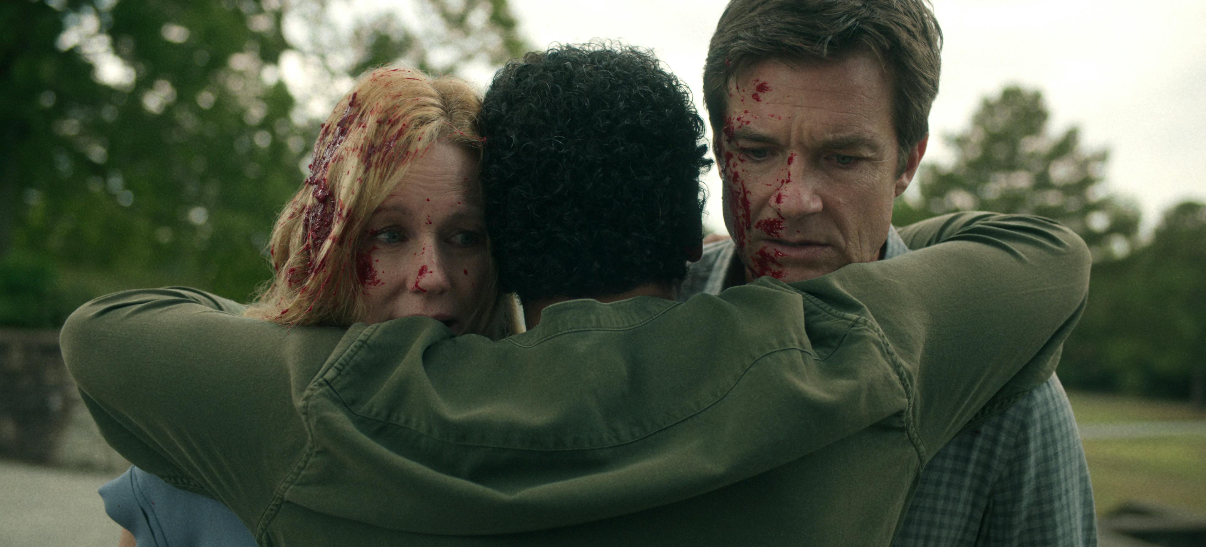 Laura Linney and Jason Bateman face the camera covered in blood.