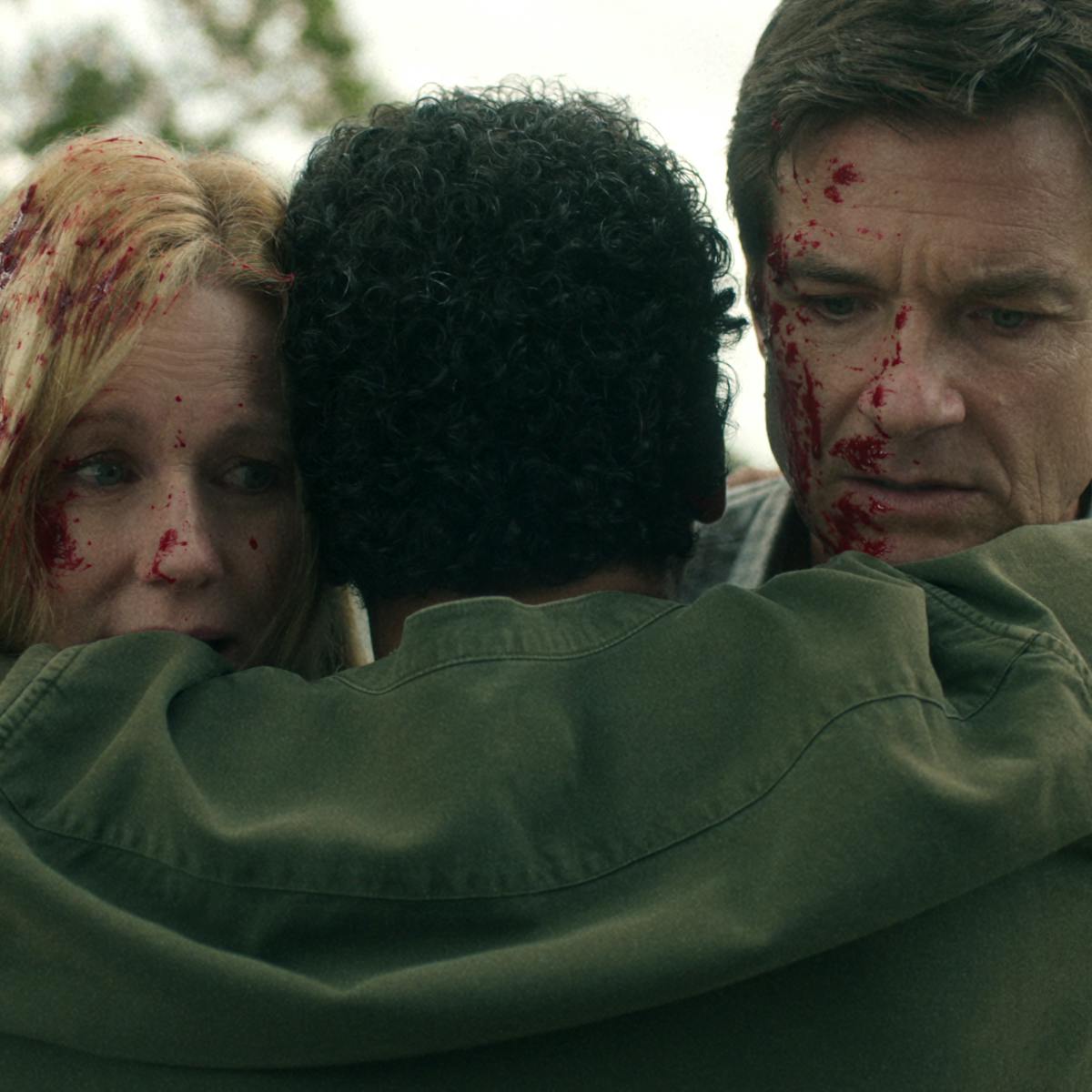 Laura Linney and Jason Bateman face the camera covered in blood.