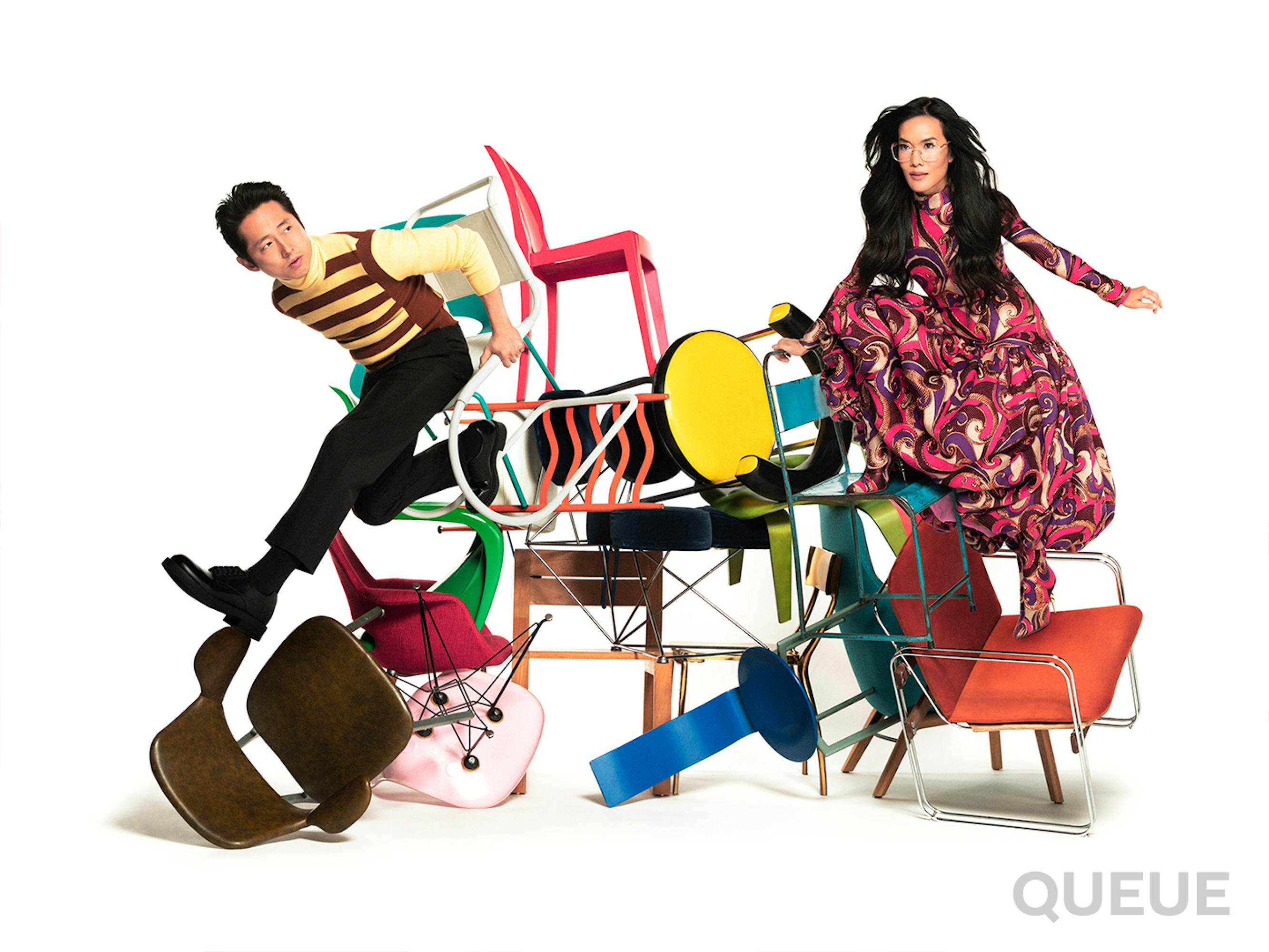 Steven Yeun and Ali Wong scramble over a pile of chairs.