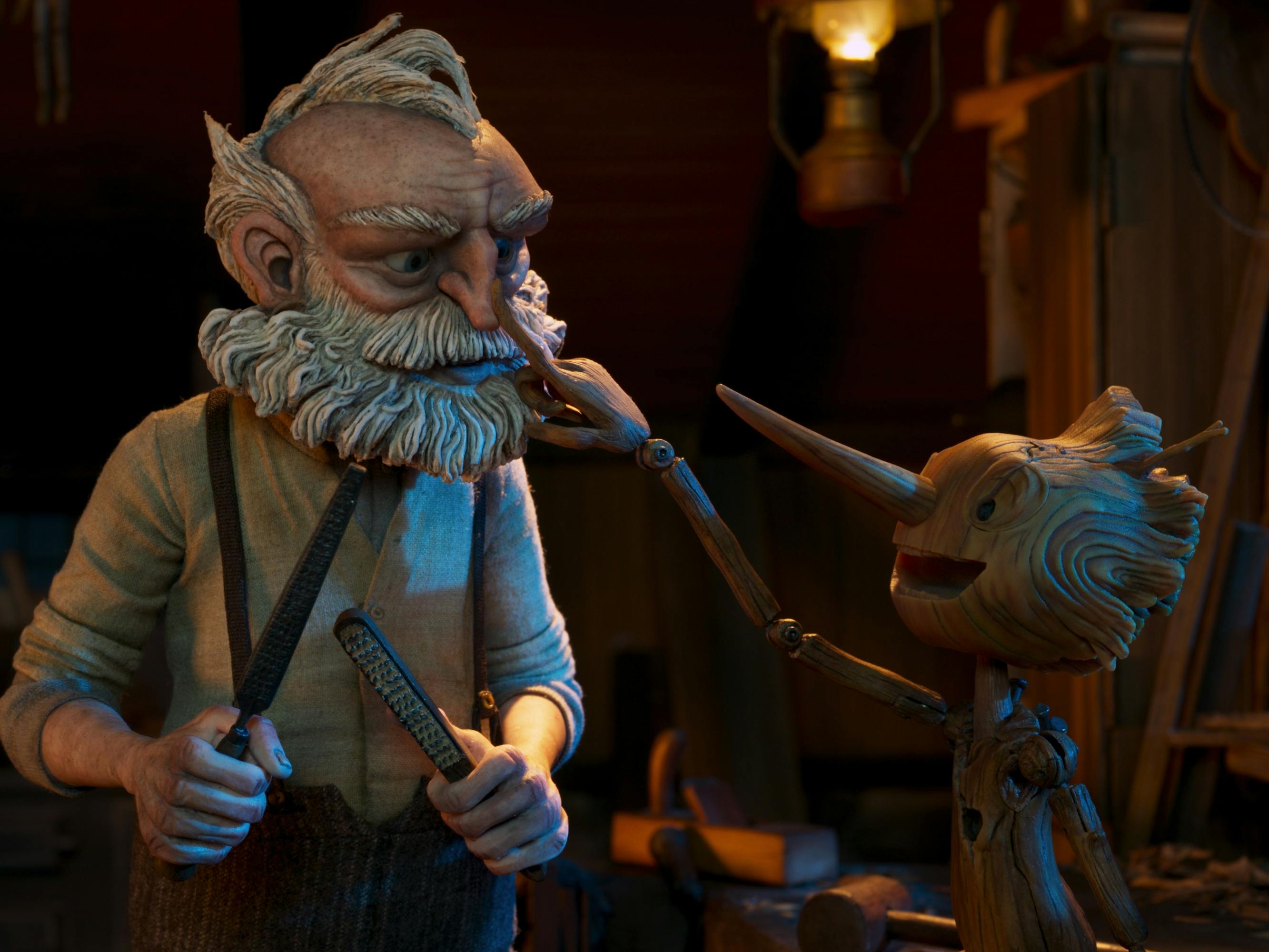 Pinocchio (Gregory Mann) taps Geppetto (David Bradley)'s nose in a dark room.