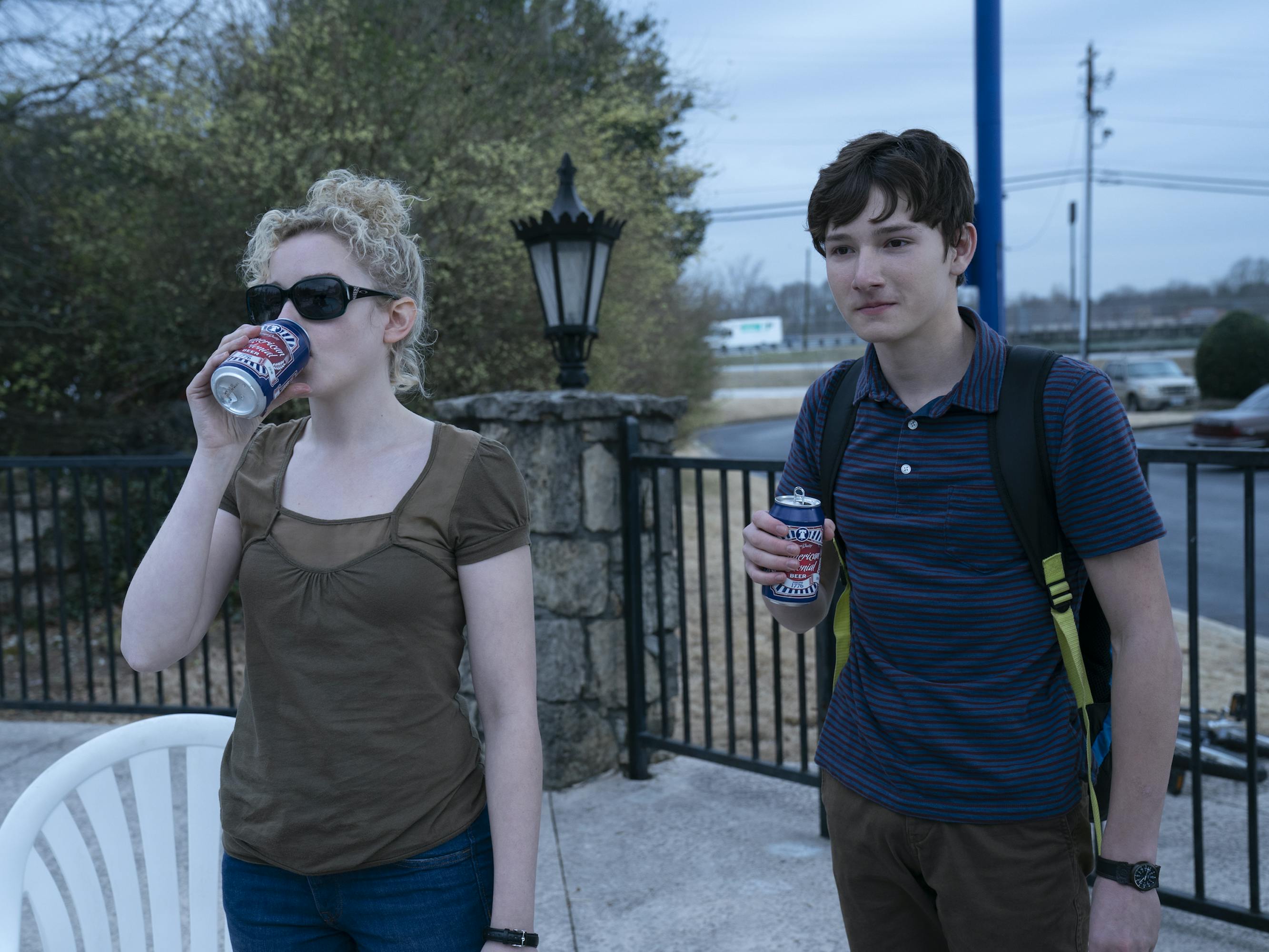 Ruth Langmore (Julia Garner) and Jonah Byrde (Skylar Gaertner) drink soda outside on a patio.