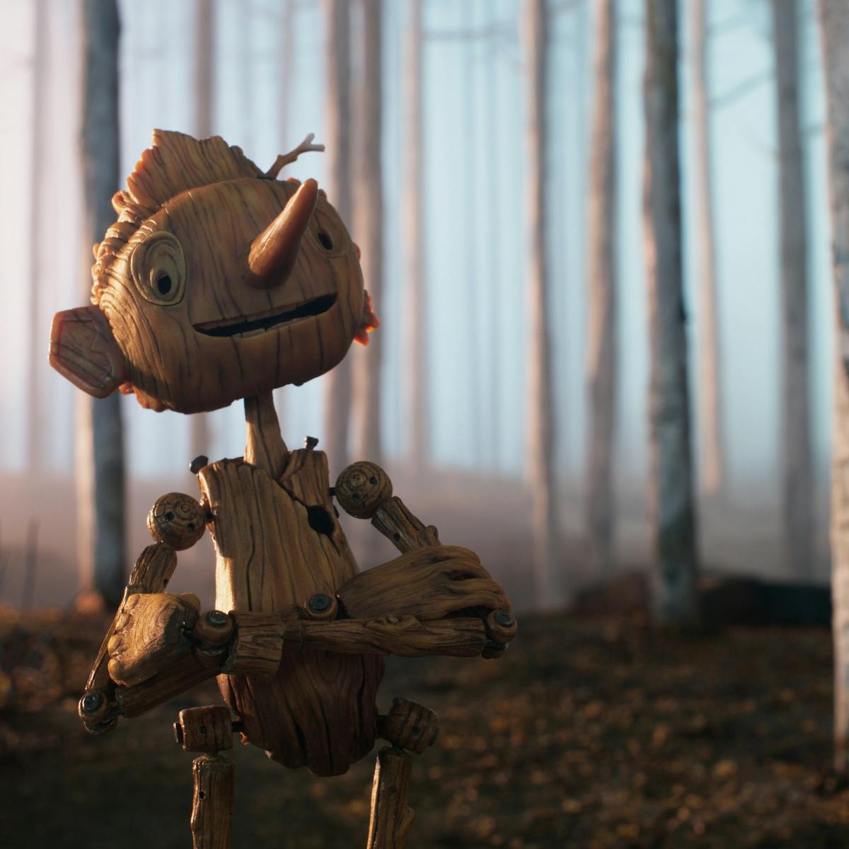 Pinocchio walks through a foggy birch forest smiling.