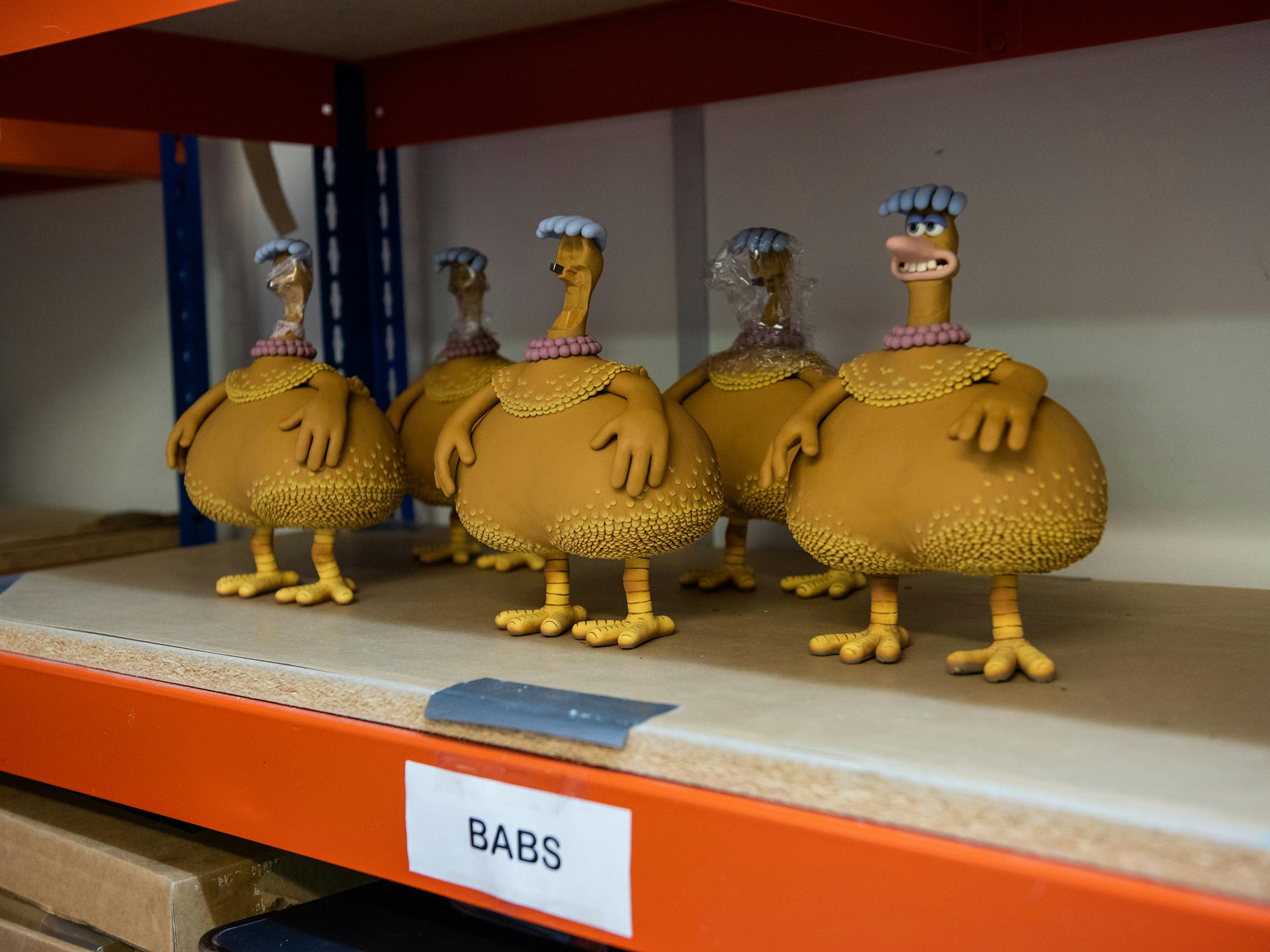 Some Babs puppets stand on an industrial shelf.