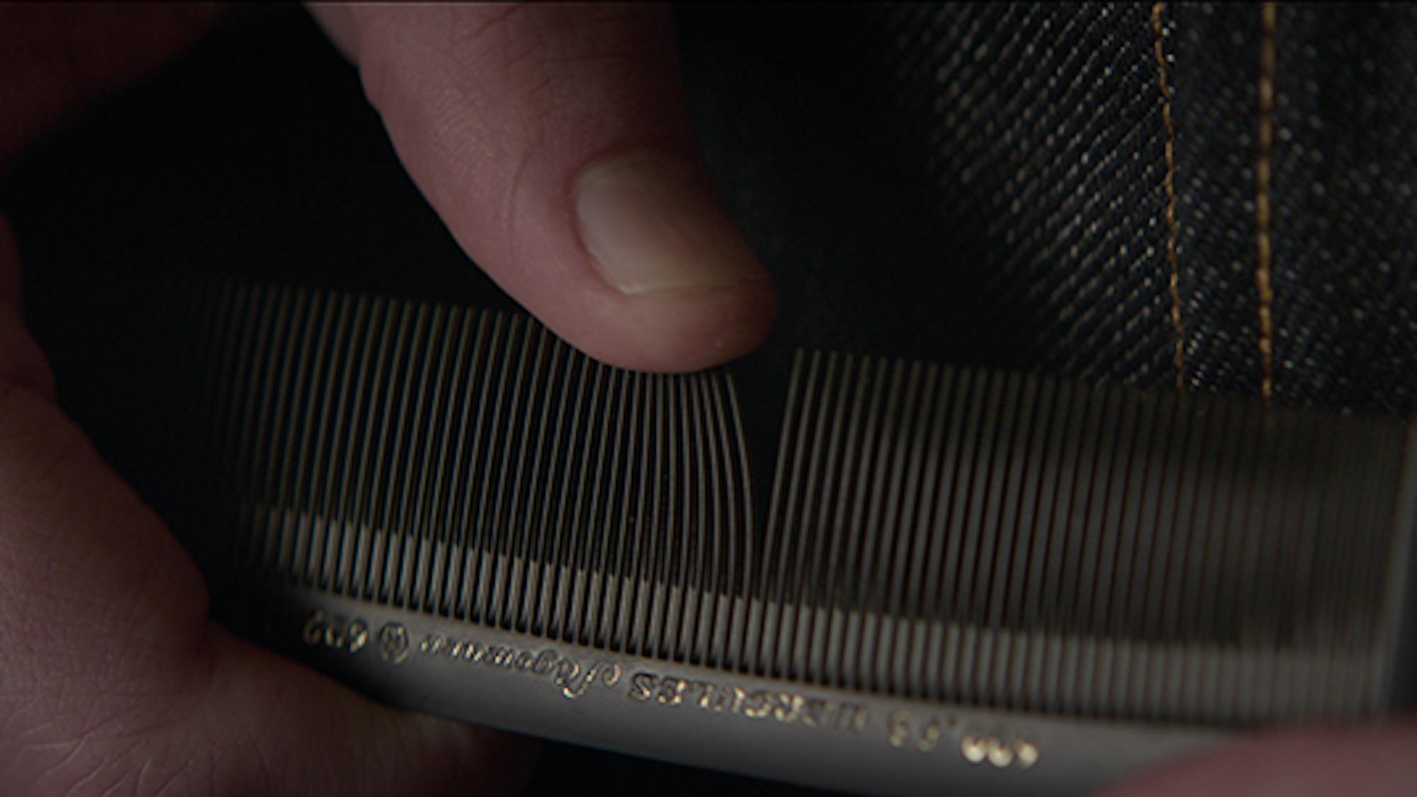 A still from The Power of the Dog that is an extremely tight crop on Peter Gordon (Kodi Smit-McPhee) running his thumb over the teeth of his comb making a distinct, almost haunting noise. The action is a nervous tic of his in the film and is a striking example of the sound design in the film. 