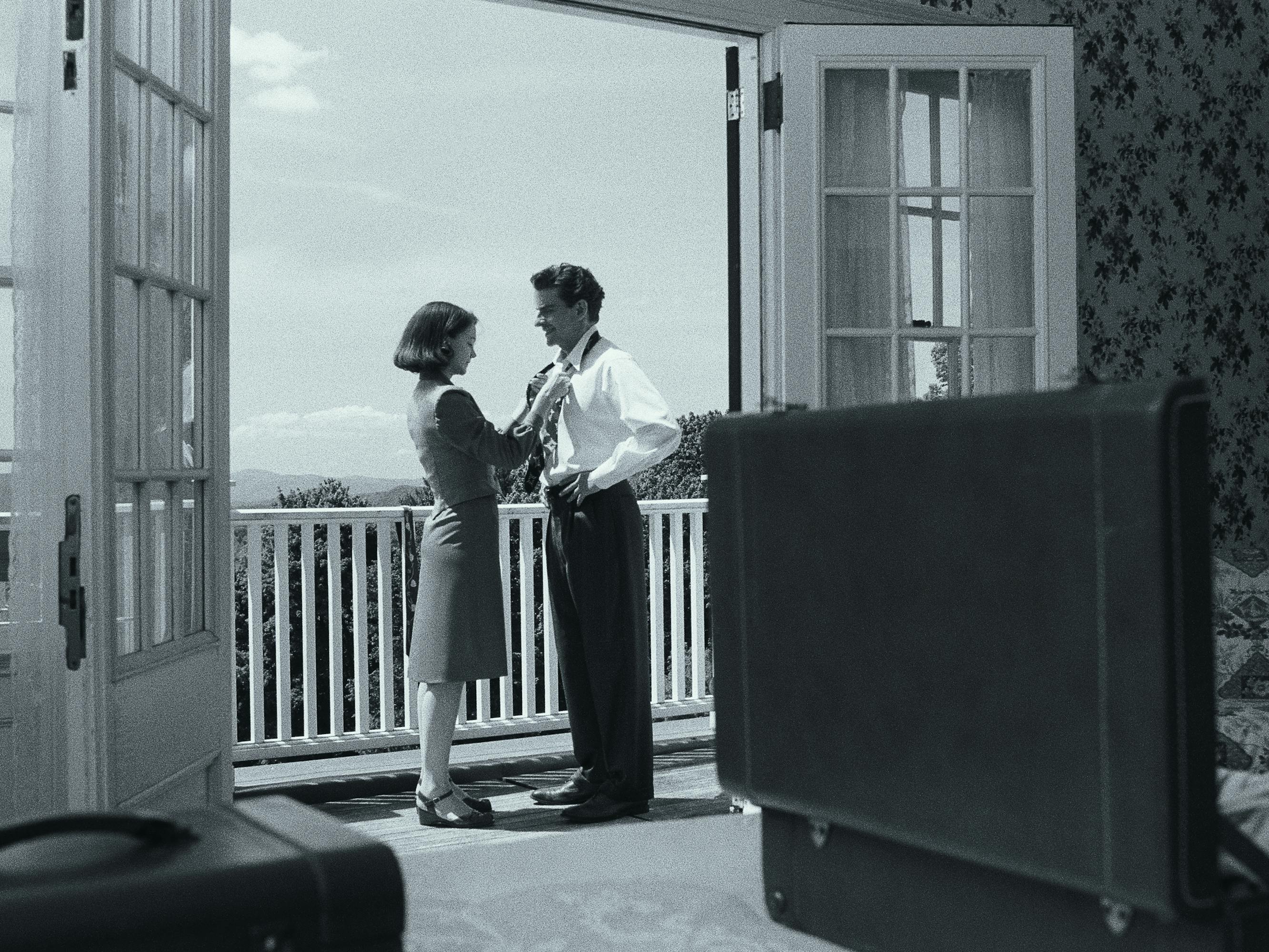 Felicia Montealegre Cohn Bernstein (Carey Mulligan) adjusts Leonard Bernstein (Bradley Cooper) tie on a veranda.