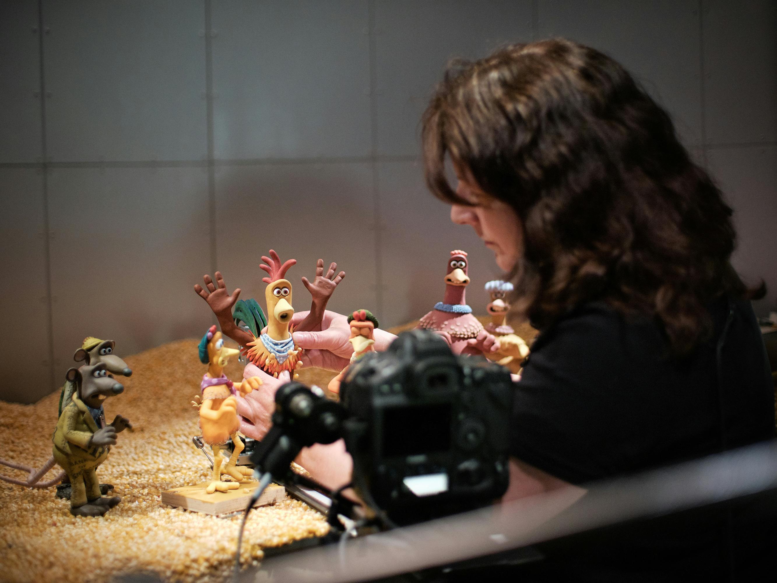 Behind the scenes, a puppeteer poses Rocky and other characters. 