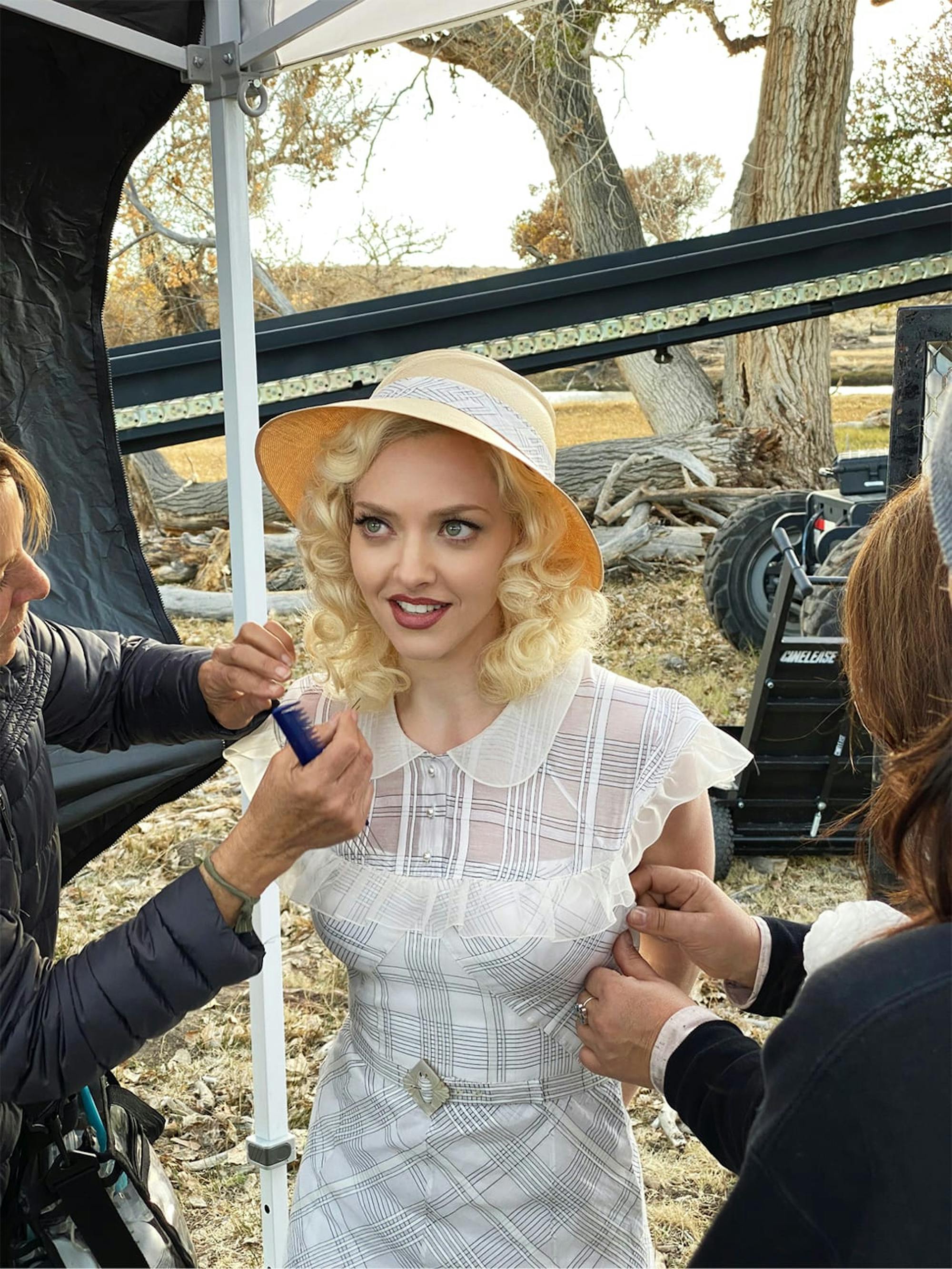 Amanda Seyfried in costume. She has straw-yellow locks, which are being combed as we speak, and is wearing a white dress, which appears to be getting it’s final alterations. 