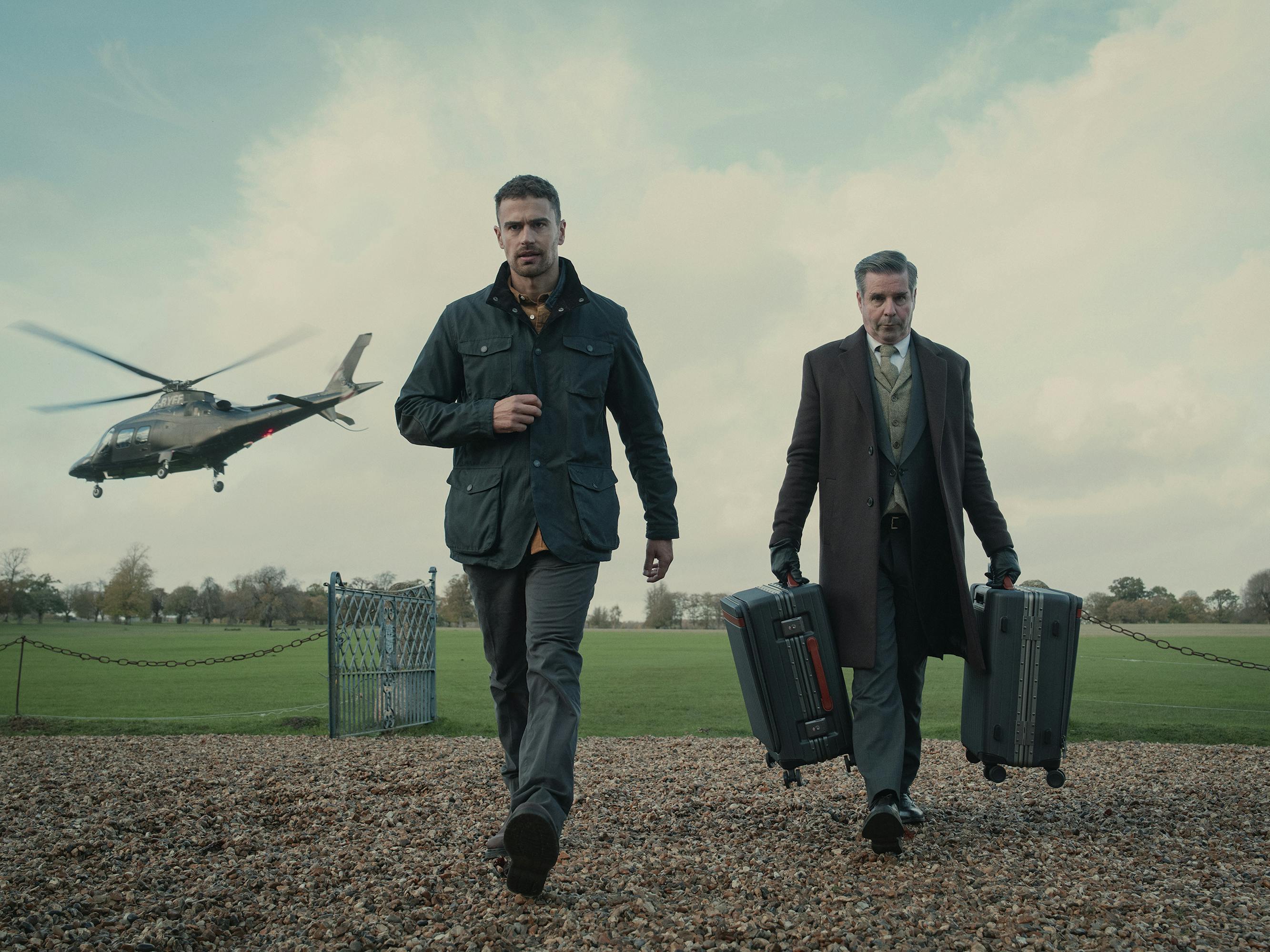  Eddie Horniman (Theo James) in The Gentlemen. Walking next to a man carrying two suitcases, James strides with purpose as a helicopter flies away in the background.