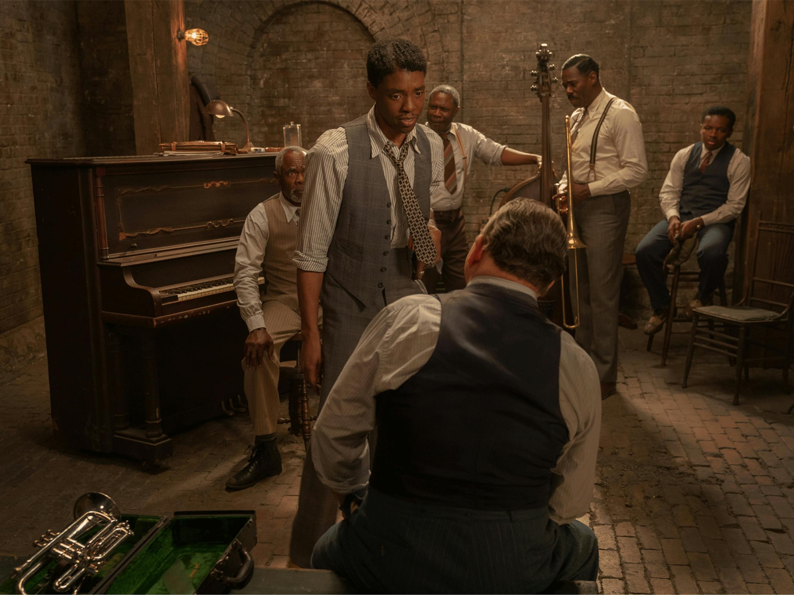 Levee stands in front of the band, talking to Sturdyvent, whose back is toward the camera.