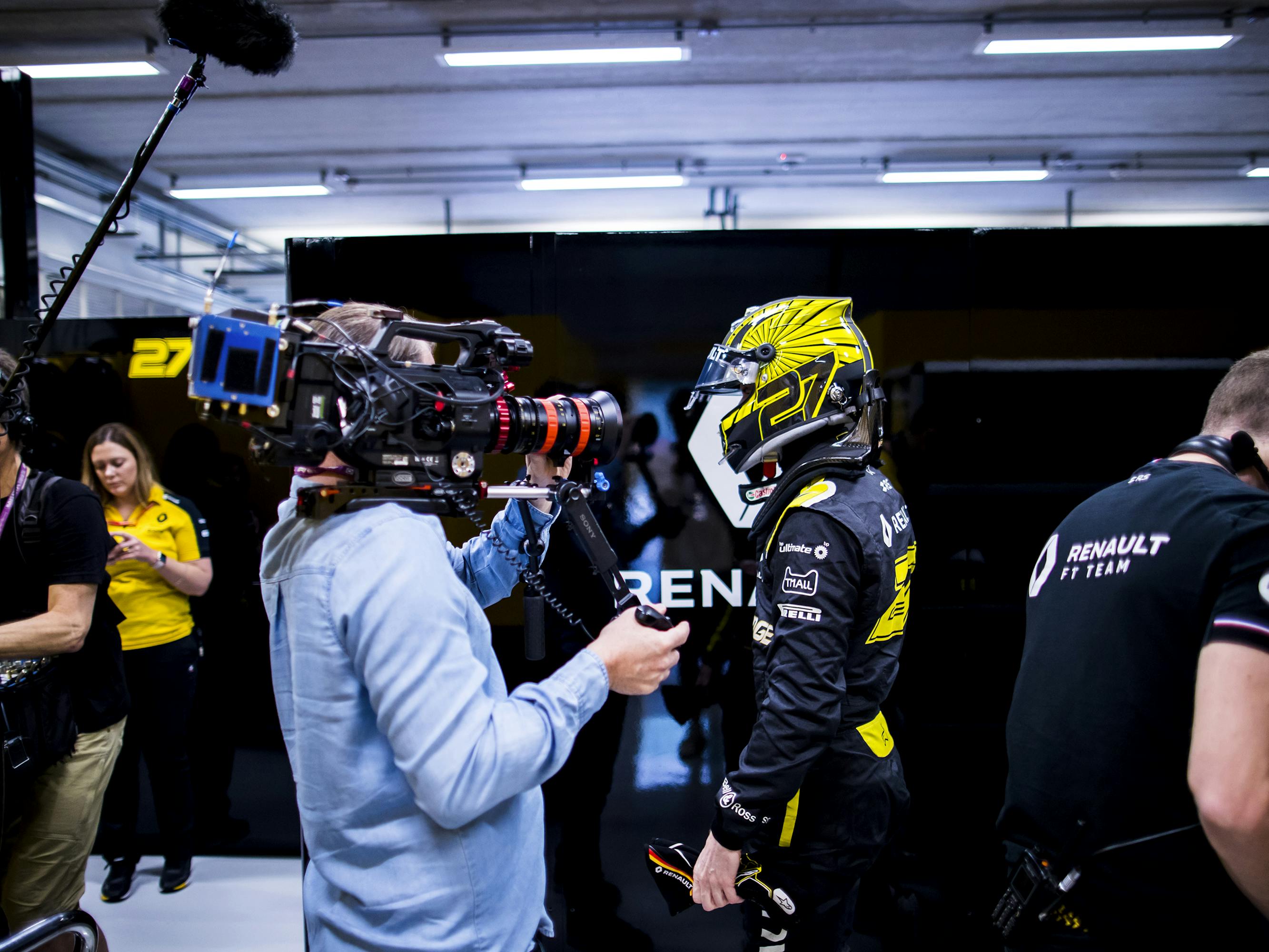 Nico Hulkenberg wears his uniform and helmet in this behind-the-scenes shot.