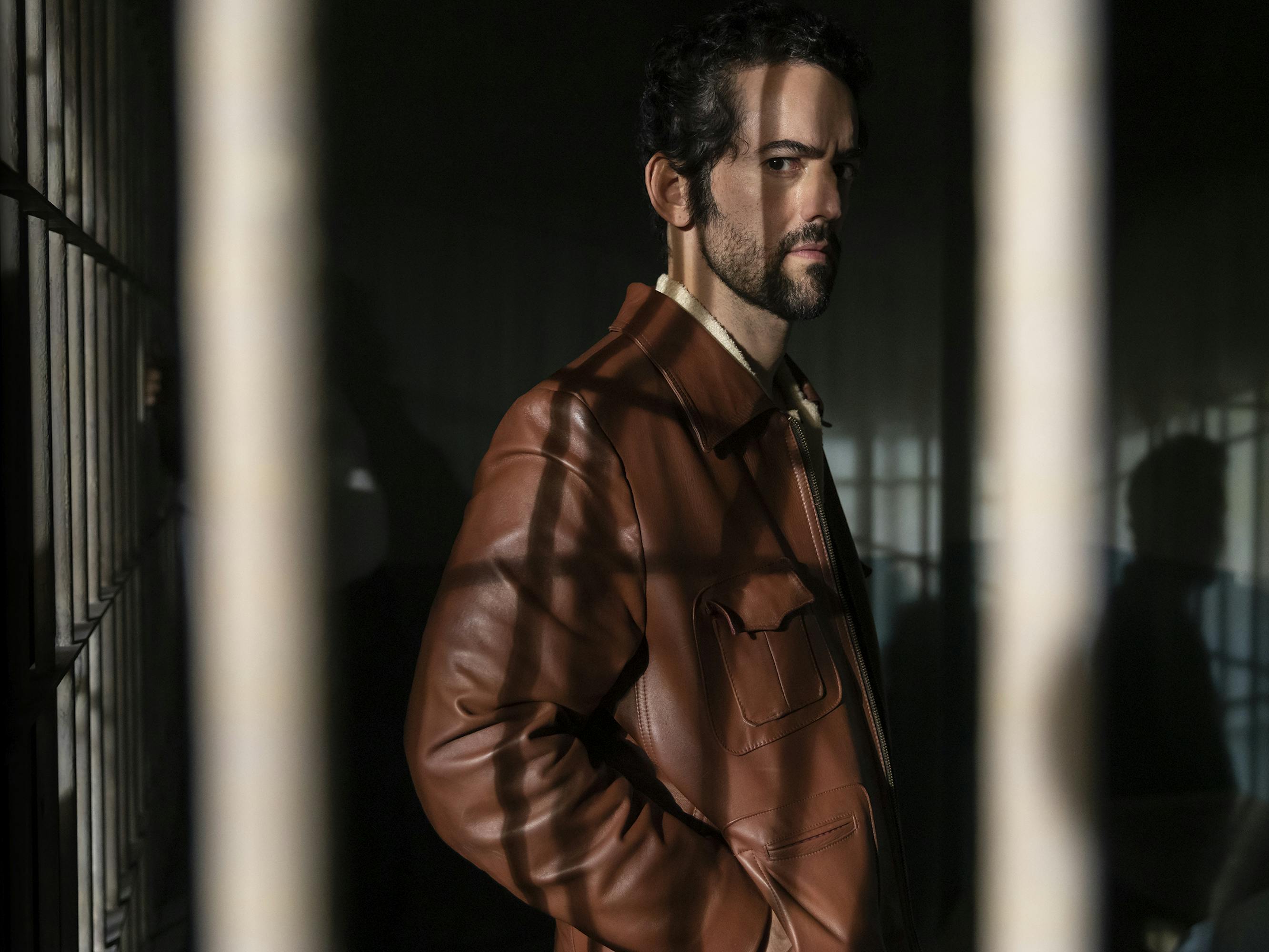 Belascoarán (Luis Gerardo Méndez) wears a brown leather jacket in this shadowy picture.