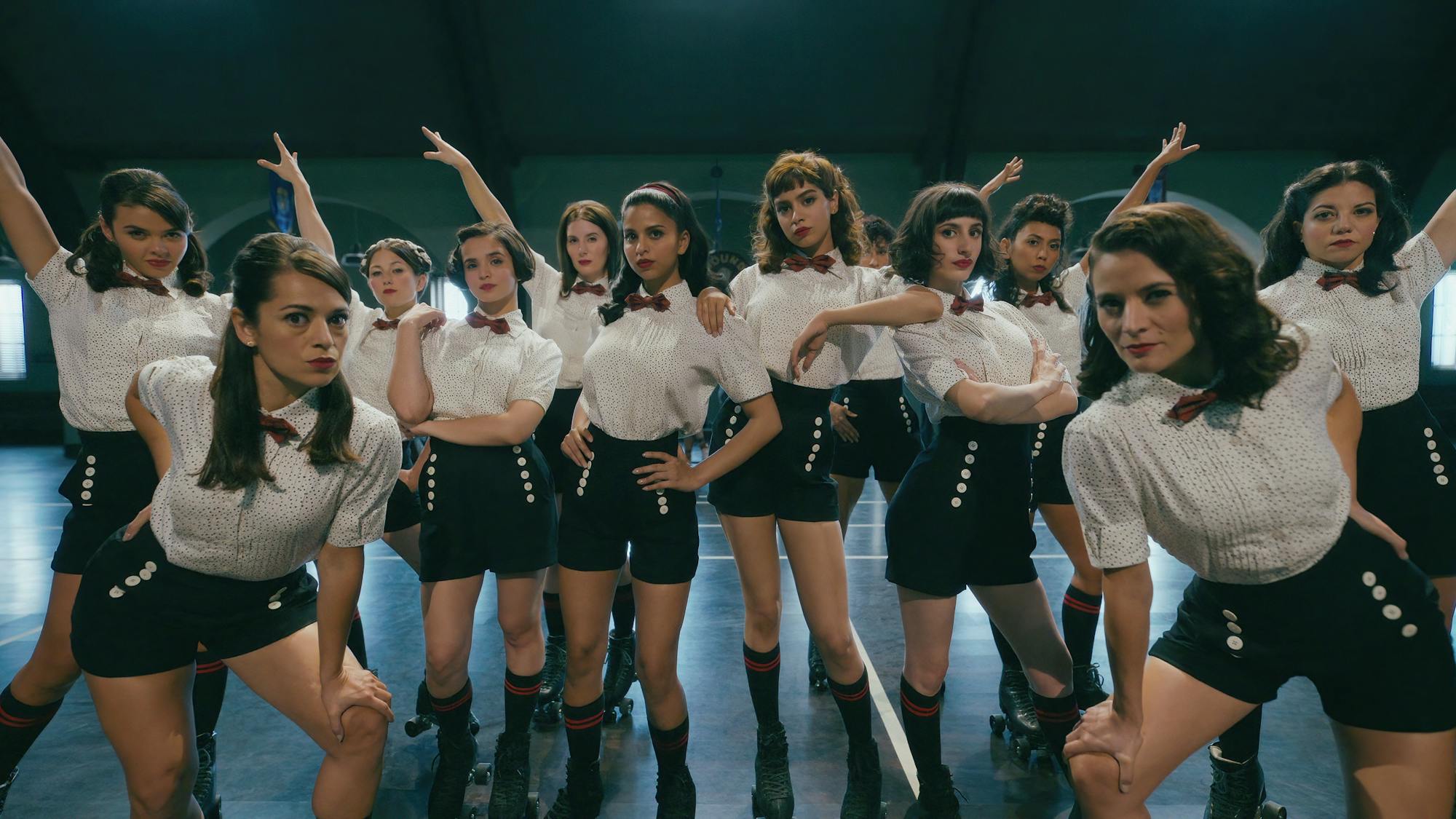 Veronica Lodge (Suhana Khan), Betty Cooper (Khushi Kapoor), and Ethel Muggs (Dot) stand around in white blouses and black shorts striking a pose.