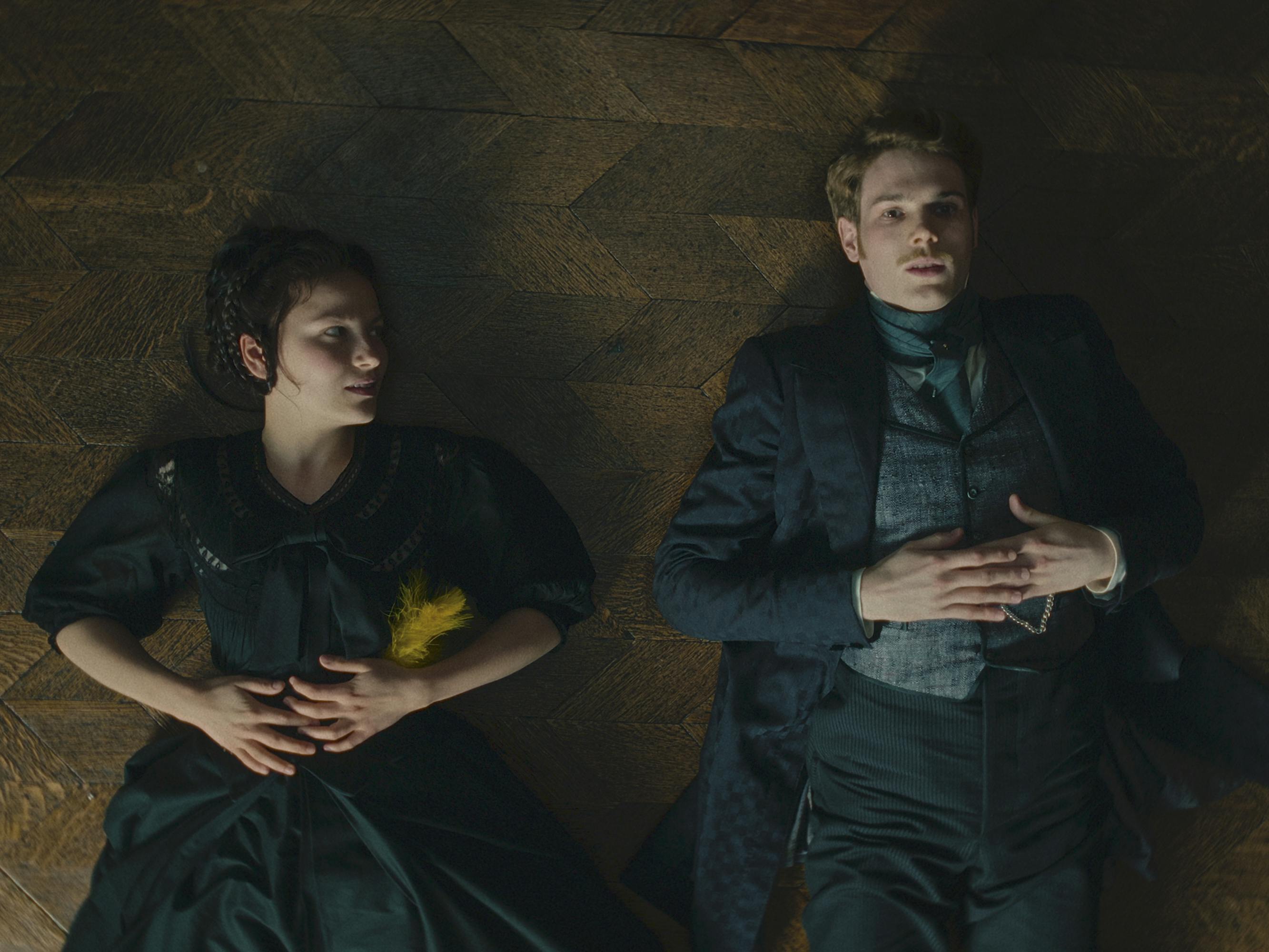 Elisabeth (Devrim Lingnau) and Franz (Philip Froissant) lie together on a cold stone ground.