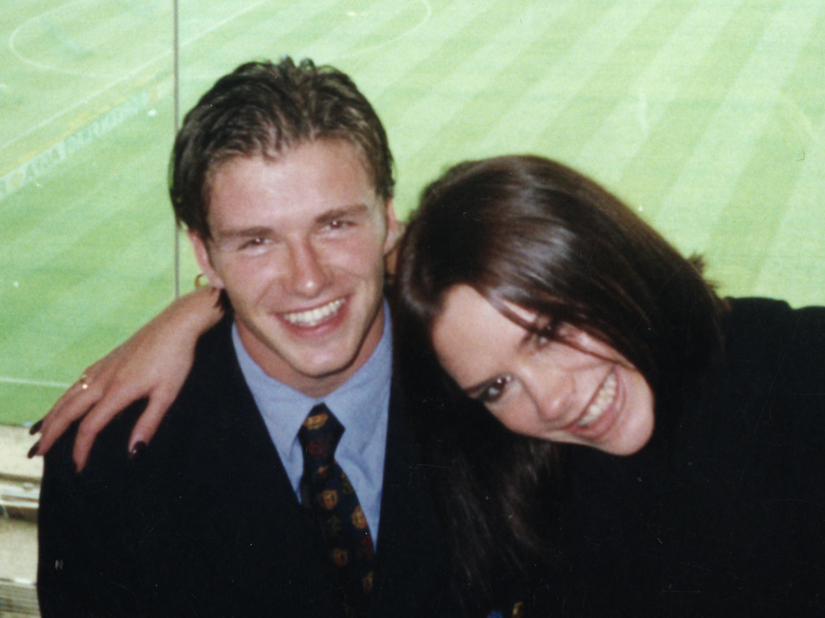 David and Victoria Beckham pose together by an empty soccer pitch. What a good-looking couple!