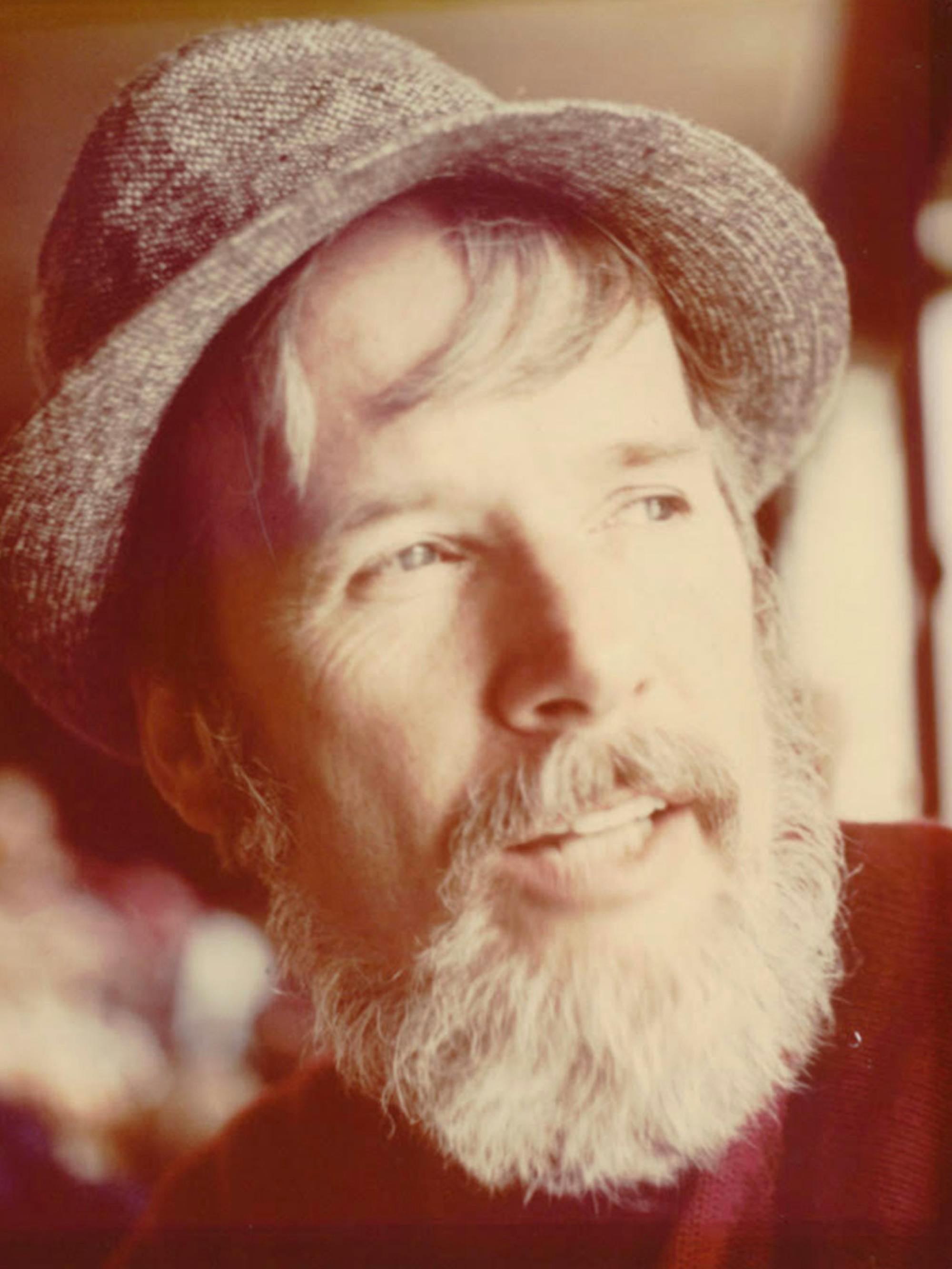 Jack Fincher sports a white beard and moustache, plus a fedora, in this sepia-toned photograph.