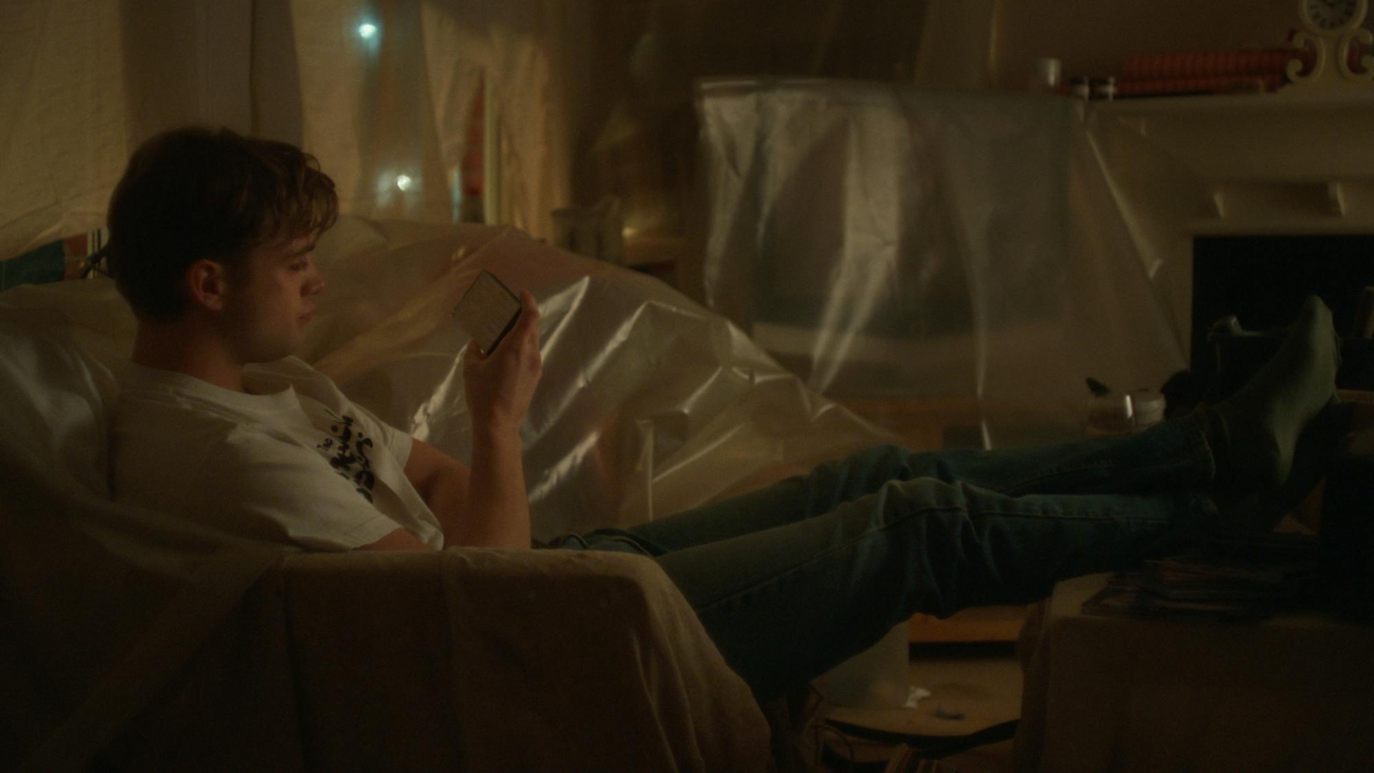 Dexter Mayhew (Leo Woodall) sits in his house, with all the furniture covered in plastic. 