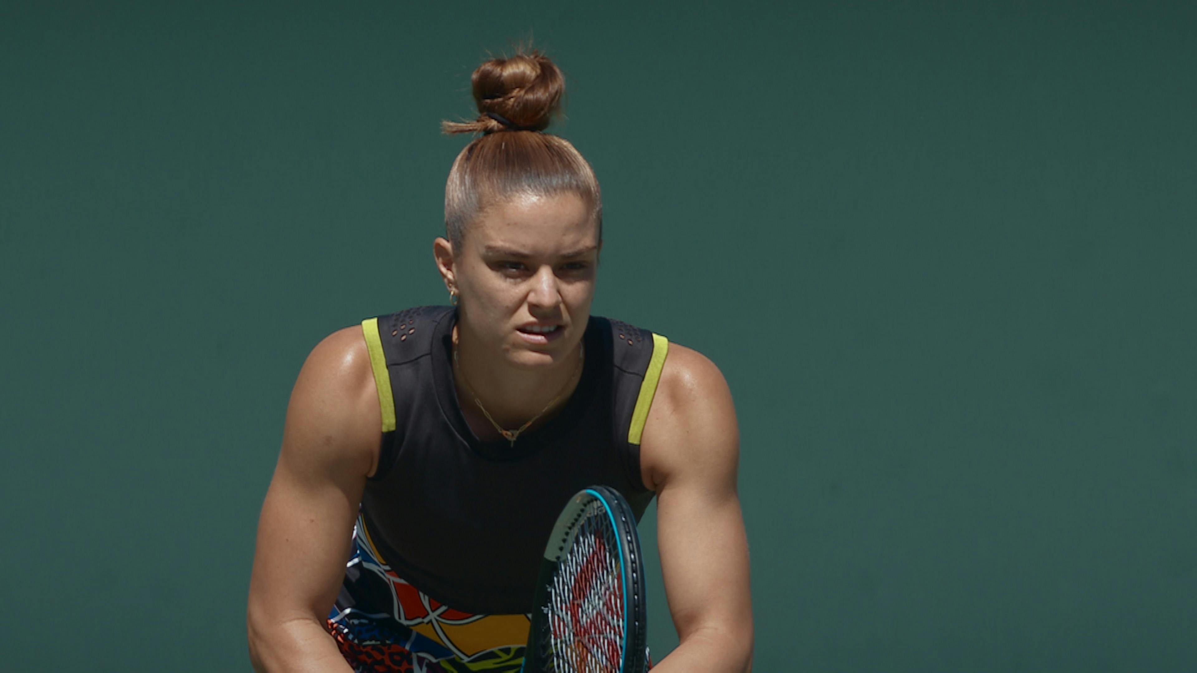 A tennis player readies herself to receive the next serve.