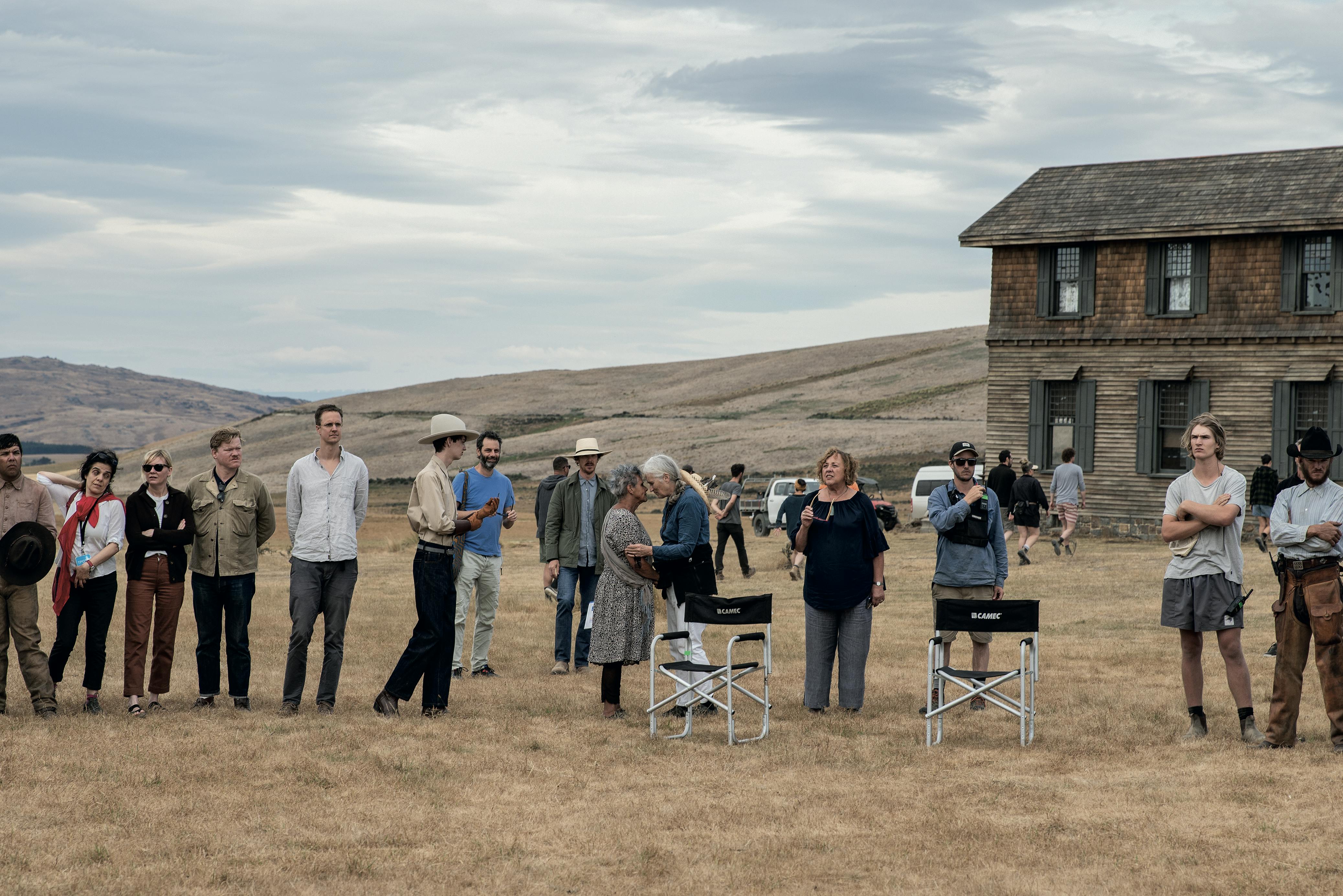 Max Mata as Juan, Kirsten Dunst as Rose Gordon, Jesse Plemons as George Burbank, Kodi Smit-McPhee as Peter, Benedict Cumberbatch as Phil Burbank, Jane Campion (Director, Producer), Josh Owen as Lee in The Power of the Dog. Everyone stand on the set of The Power of the Dog as they bless the site with a member of the inuit community in New Zealand.