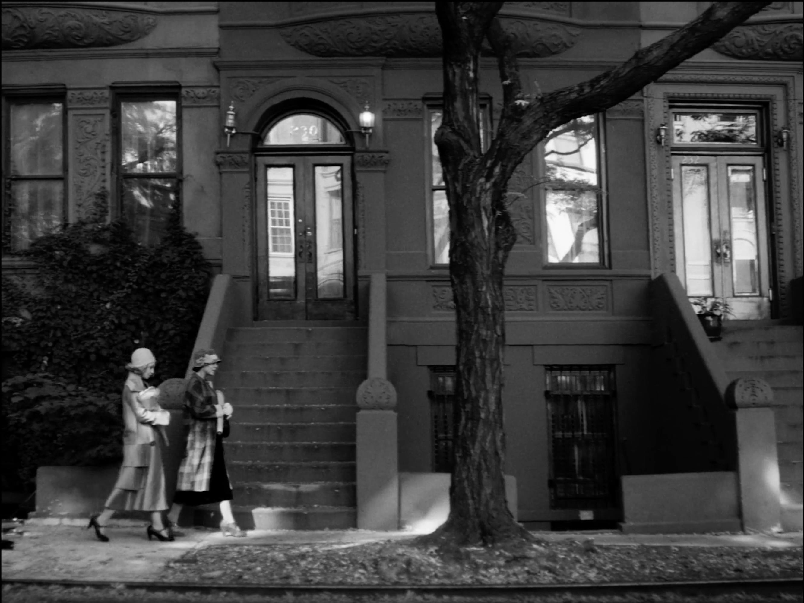 Clare (Ruth Negga) and Irene (Tessa Thompson) walk past beautiful brownstones in this black-and-white shot.