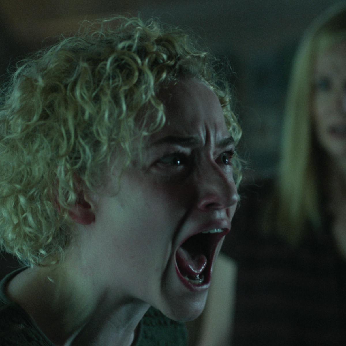 Ruth Langmore (Julia Garner) screams at someone off camera, while Wendy Bryde (Laura Linney) looks on in shock. Garner's blond curls frame her beet red face.