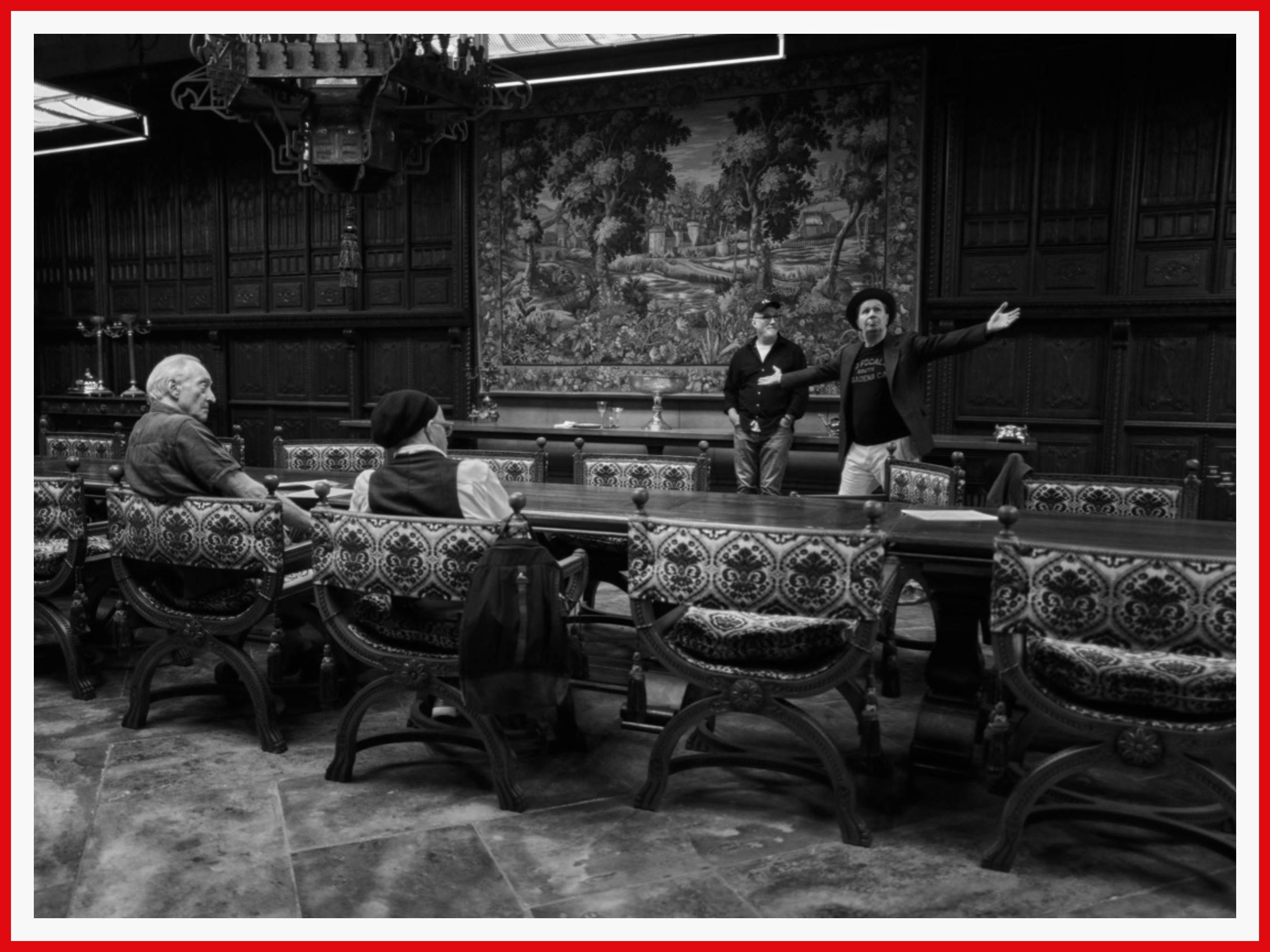 A sweeping shot of the re-created dining hall at San Simeon, with crew stationed at either side of an enormous table